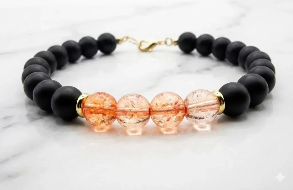 Handmade gemstone bracelet showcasing the textural contrast between smooth matte black onyx and light-catching pink crackle quartz.