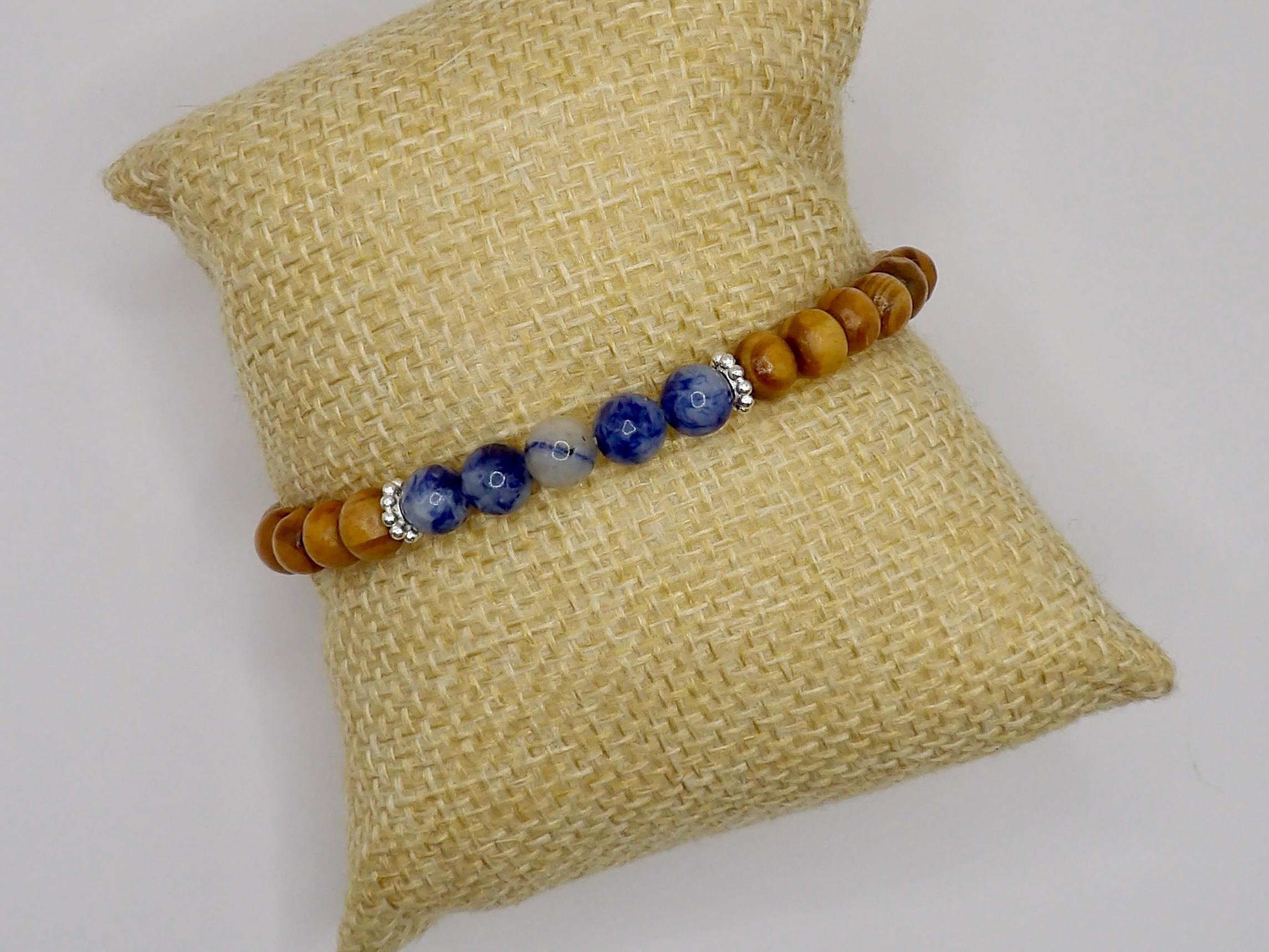 a nature-inspired jewelry piece showing the contrast between earthy wood textures and the rich midnight blue of polished sodalite.
