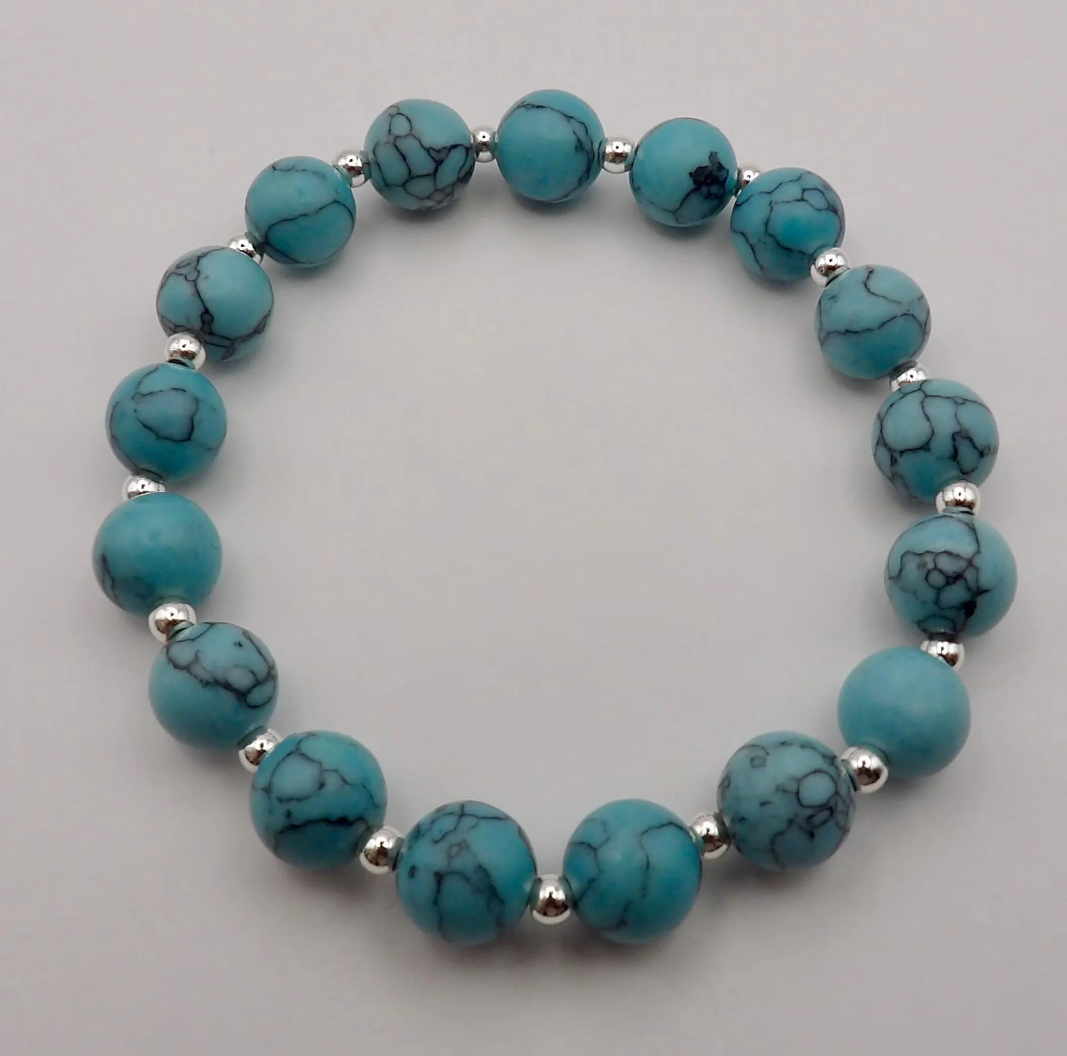 handcrafted tarnish-resistant turquoise jewelry designed for a seamless, comfortable stretch fit on a clean coastal linen background.