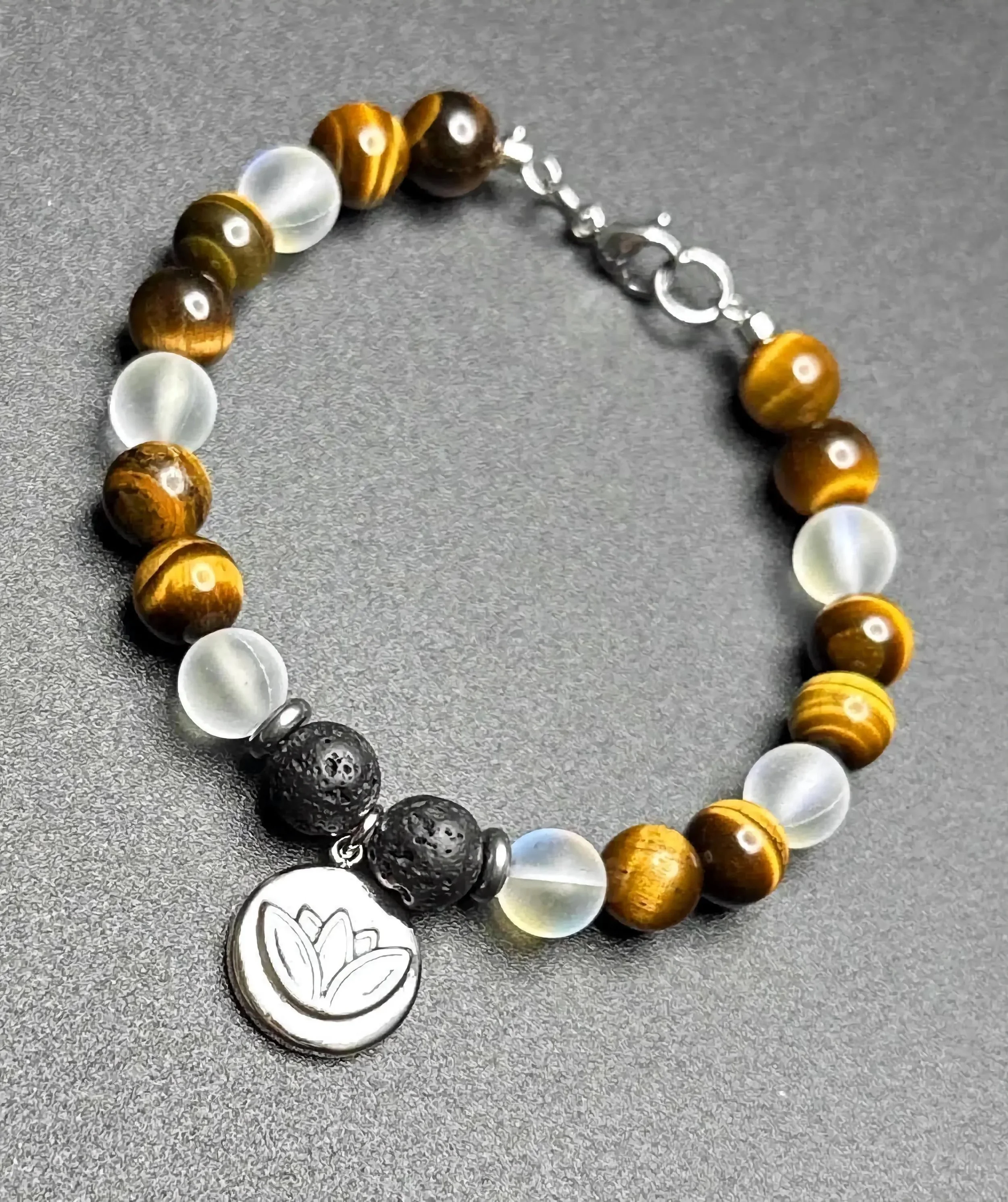 durable 304 stainless steel lotus focal bead on a gemstone strand of tiger's eye, lava rock, and natural spectrolite.