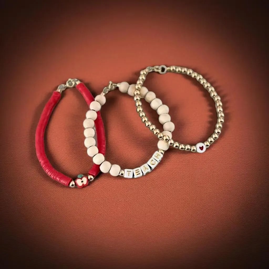 handcrafted teacher appreciation gift set featuring three 18k gold plated 5mm bead bracelets with a red apple charm and "teach" letter beads.
