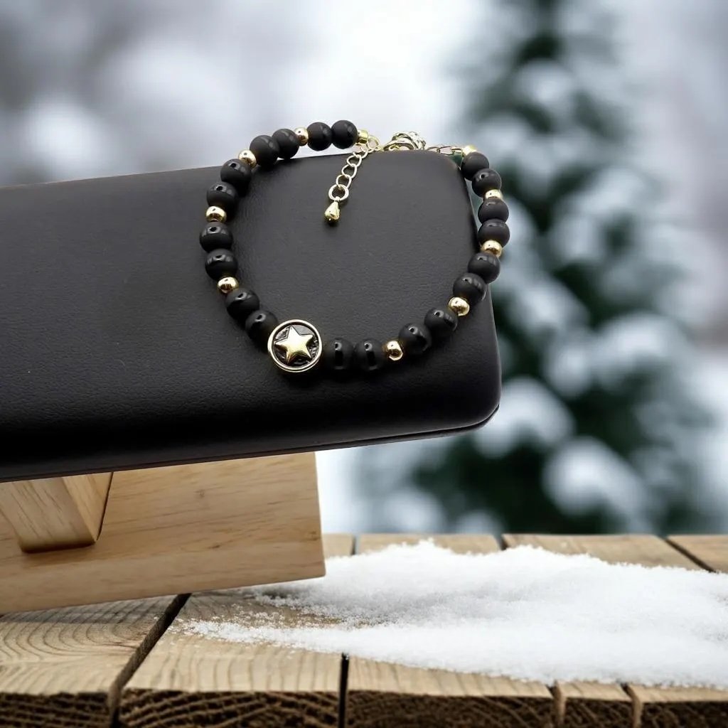 close-up of the urban dreamer bracelet highlighting the texture play of the mixed-finish onyx beads and the sharp lines of the adjustable gold closure.