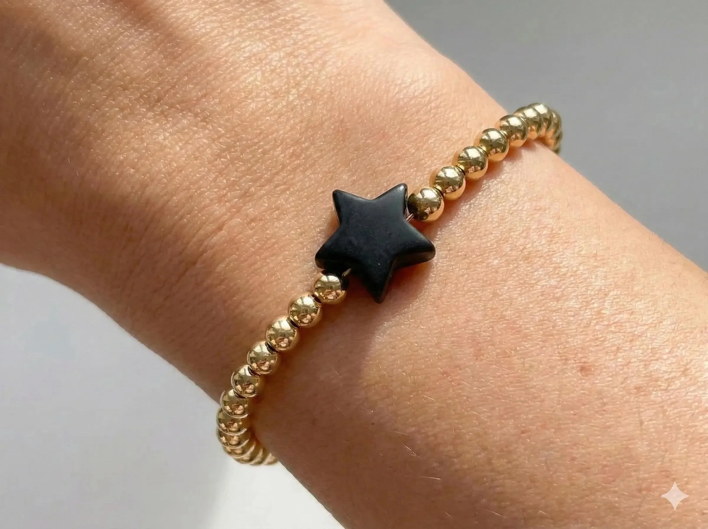 18k gold plated bead bracelet on a wrist with a soft silicone star charm in custom colors.