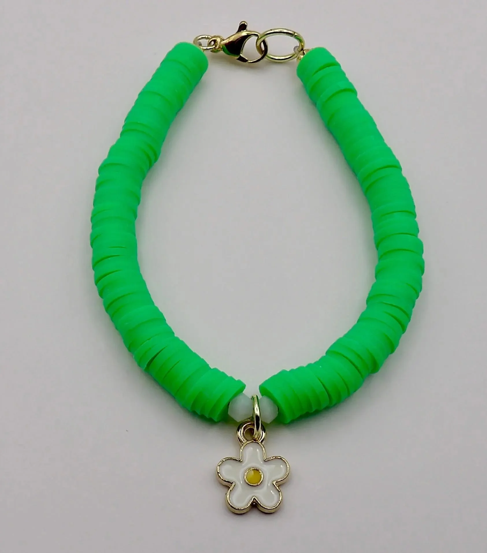 the sunny daisy bracelet styled in a bright, sunlit setting to emphasize the vibrancy of the green beads and gold hardware.