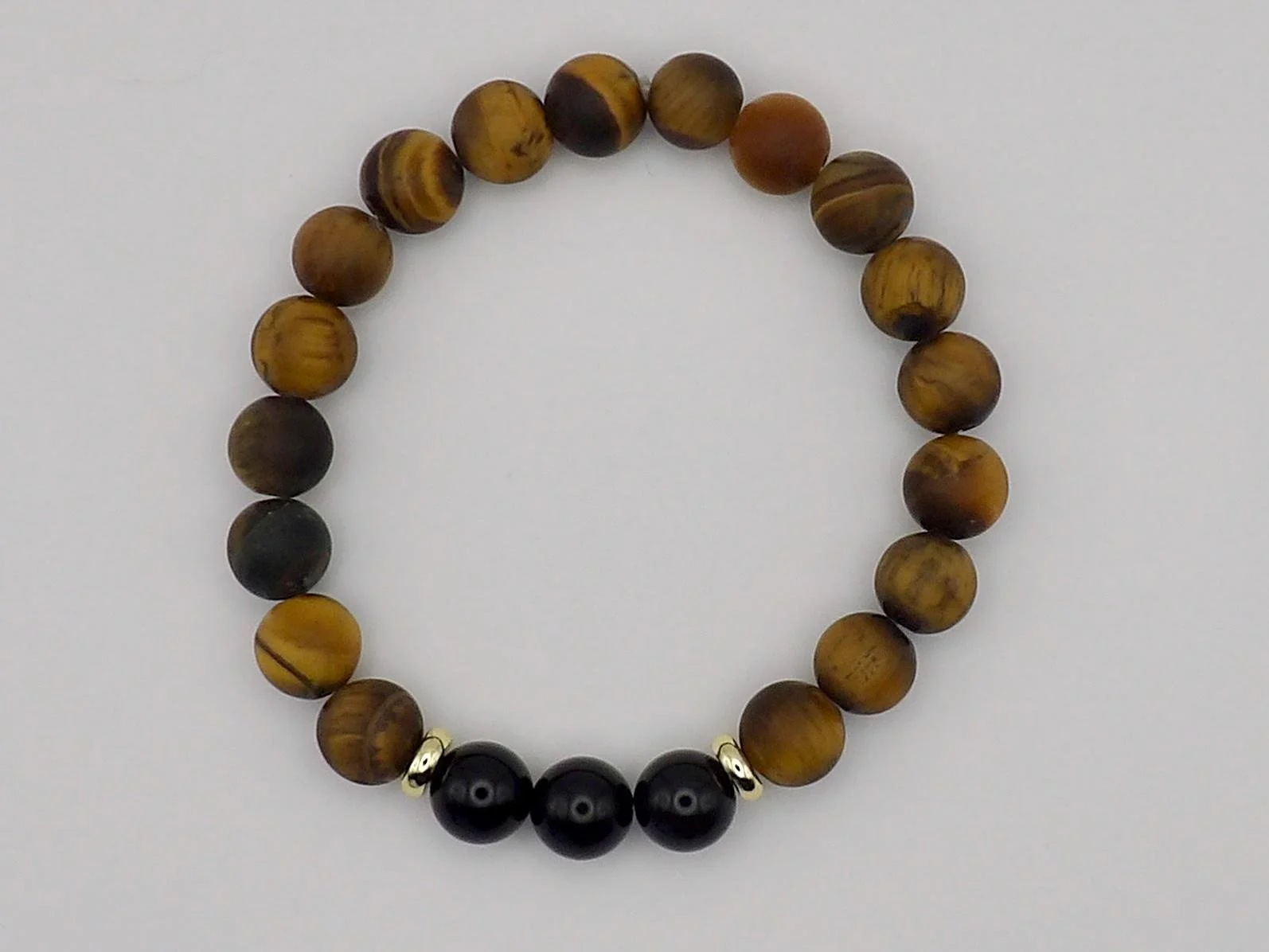 close-up of the balanced stoic bracelet highlighting the professional finish of the gold-plated beads and polished gemstones.