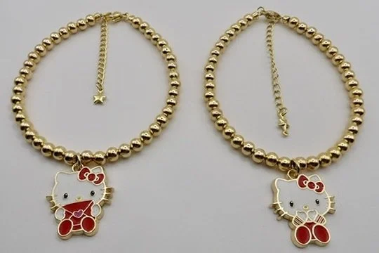 close-up detail of the 18k solid gold and enamel hello kitty charm holding an envelope, on a solid gold beaded bracelet.