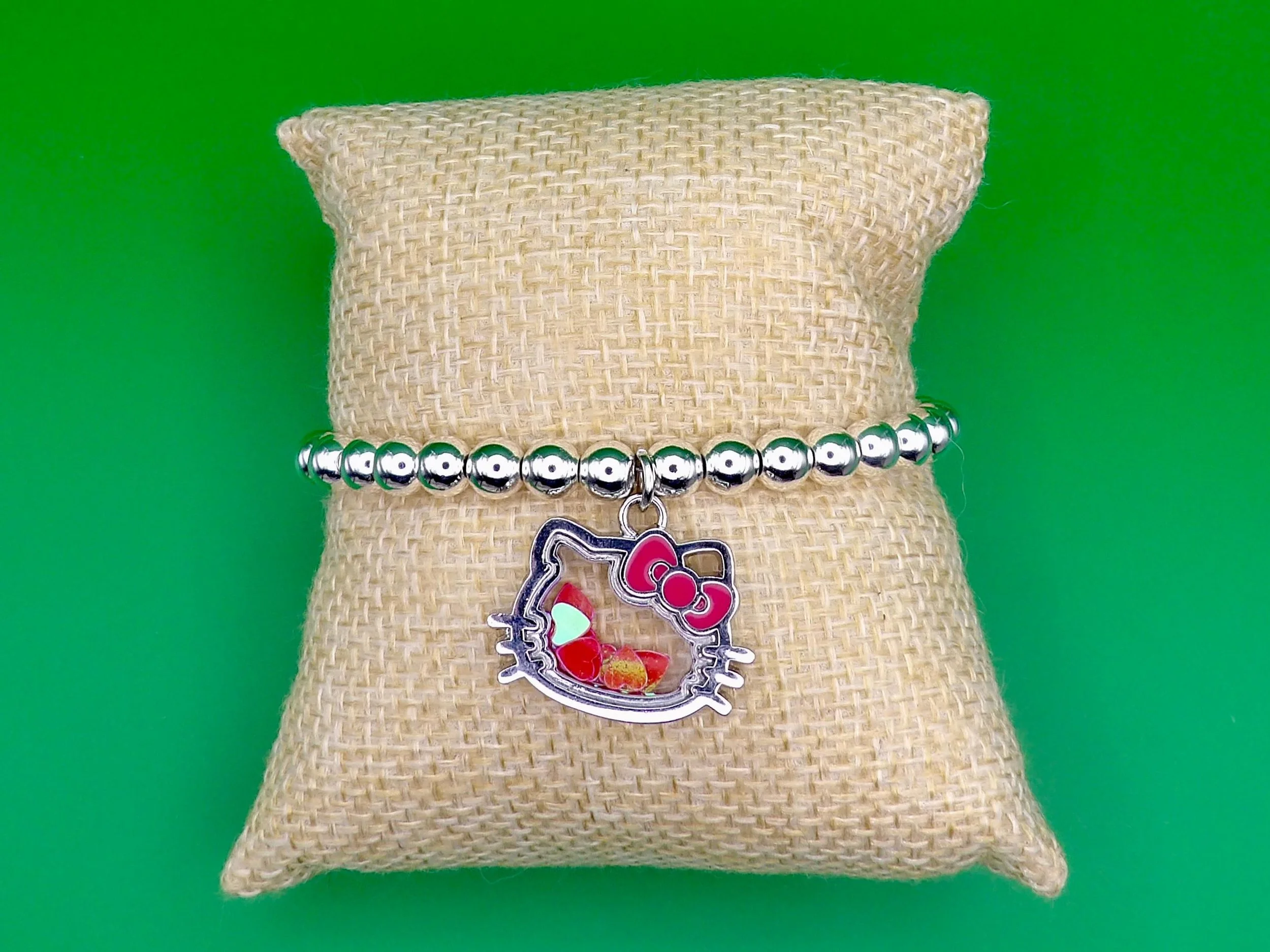 a high-end "coquette-luxe" hello kitty bracelet designed with tarnish-resistant sterling silver for long-term wear.