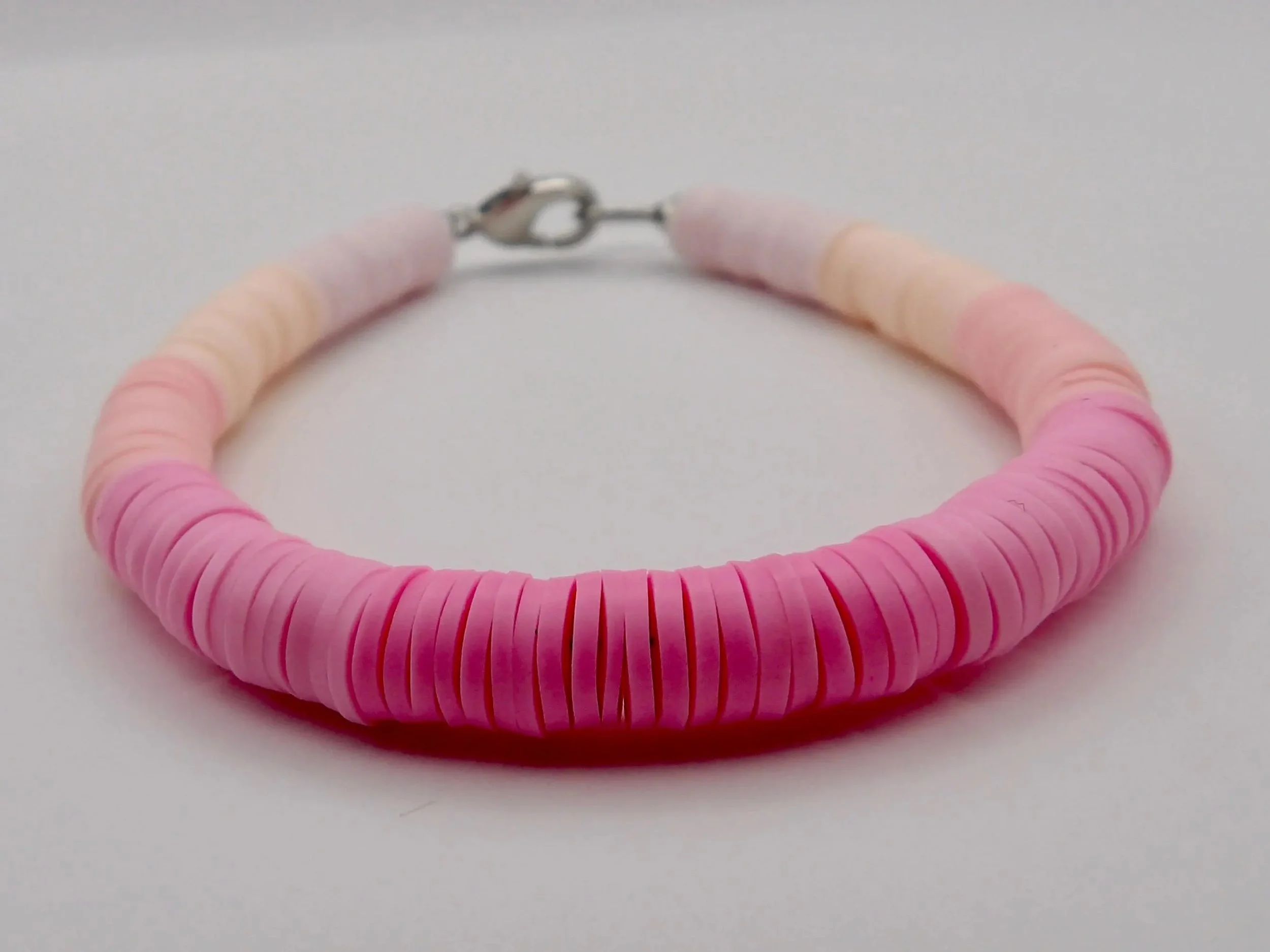 a minimalist pink gradient bead bracelet designed for the "organized creative" aesthetic with high-quality stainless steel accents.