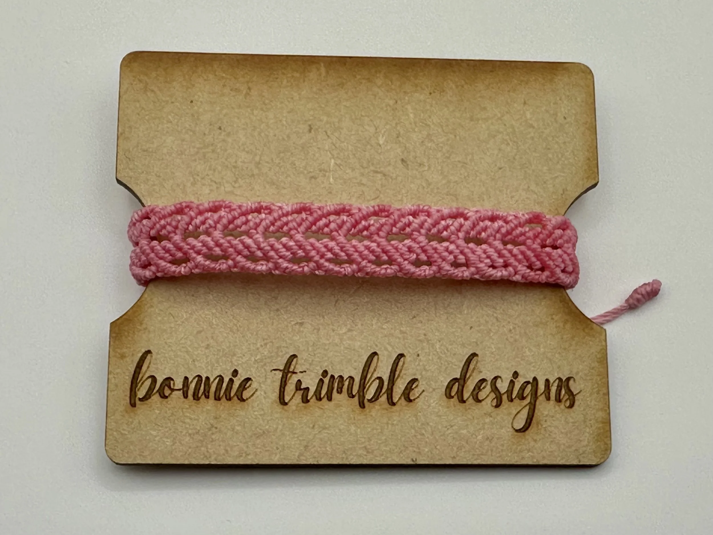 woman wearing the dainty pink chevron macrame bracelet, showing adjustable fit. perfect boho stacking bracelet.