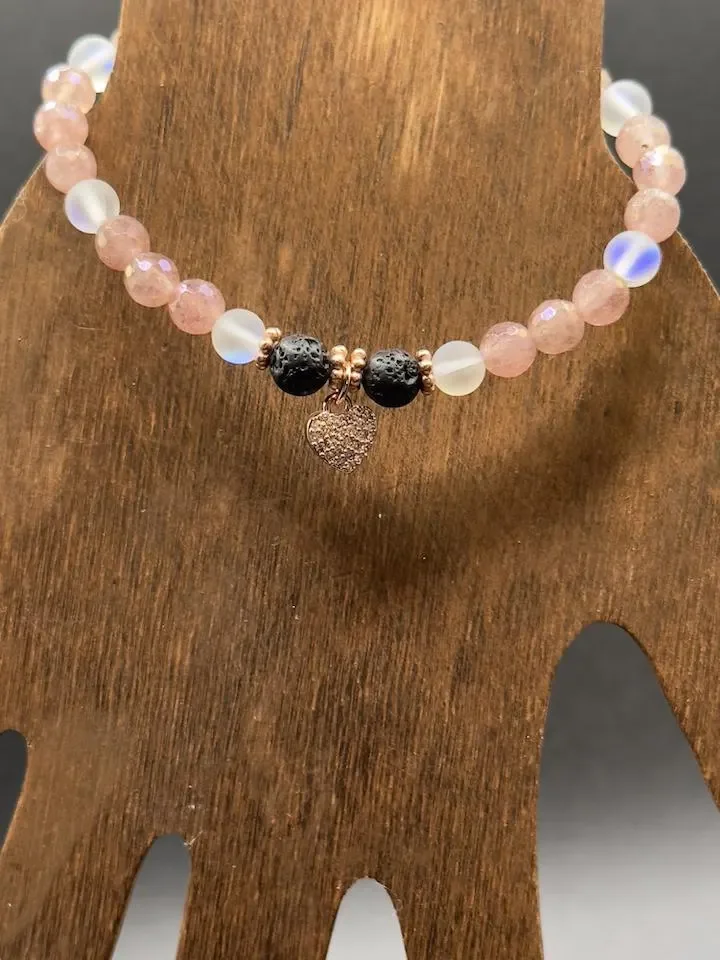 A model wearing the strawberry quartz and lava rock bracelet to showcase its size and how it pairs with everyday fashion.
