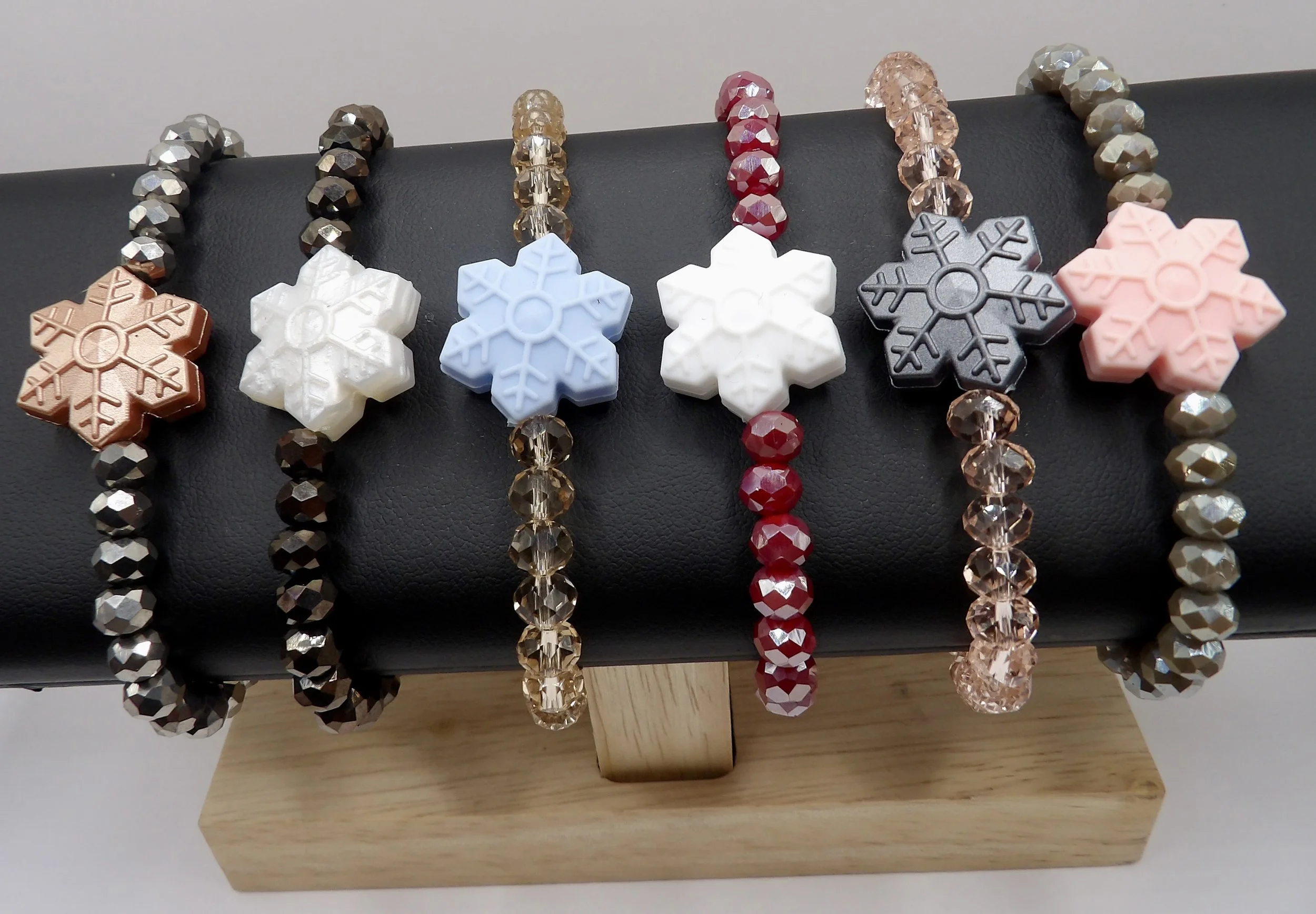 all 6 colors of the handmade snowflake bracelet with faceted glass beads and stainless steel clasps, shown together in a collection.