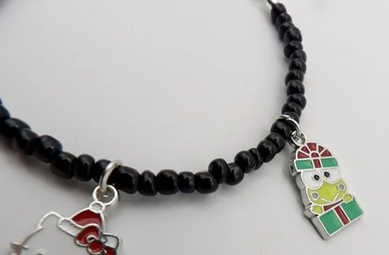 close-up detail of the sterling silver & enamel my melody charm dressed as mrs. claus for christmas.