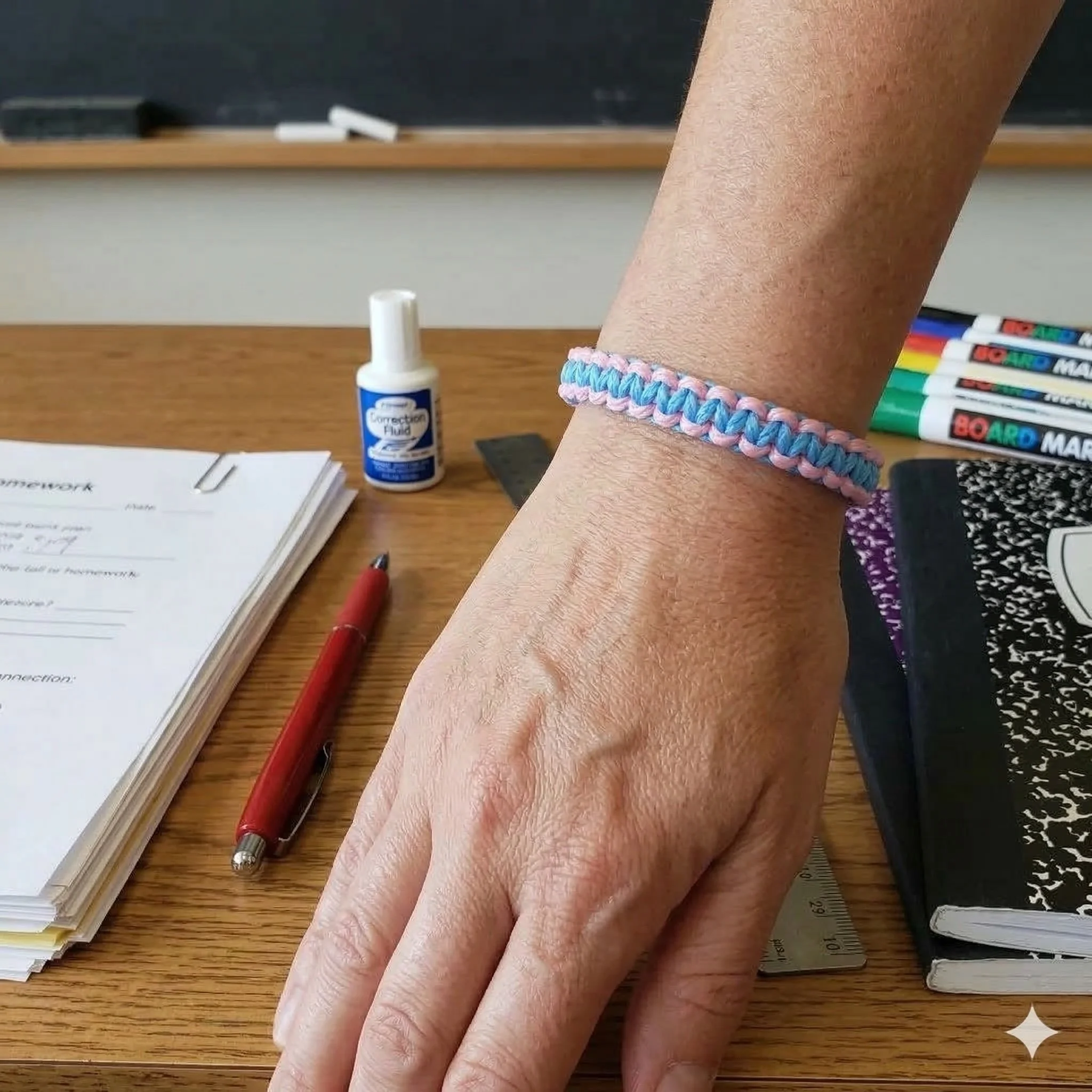 handmade two-tone pink and blue macramé friendship bracelet on a wrist with natural wood bead adjustable ties.