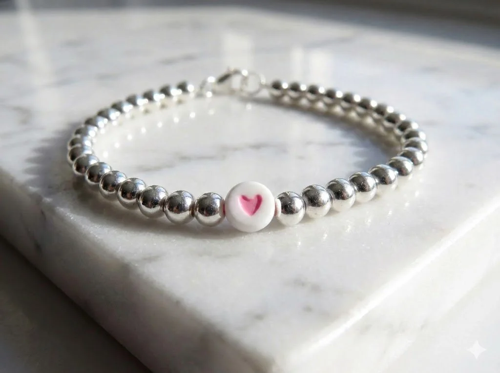 handmade dainty 5mm sterling silver beaded bracelet featuring a small pink heart bead. minimalist everyday jewelry.