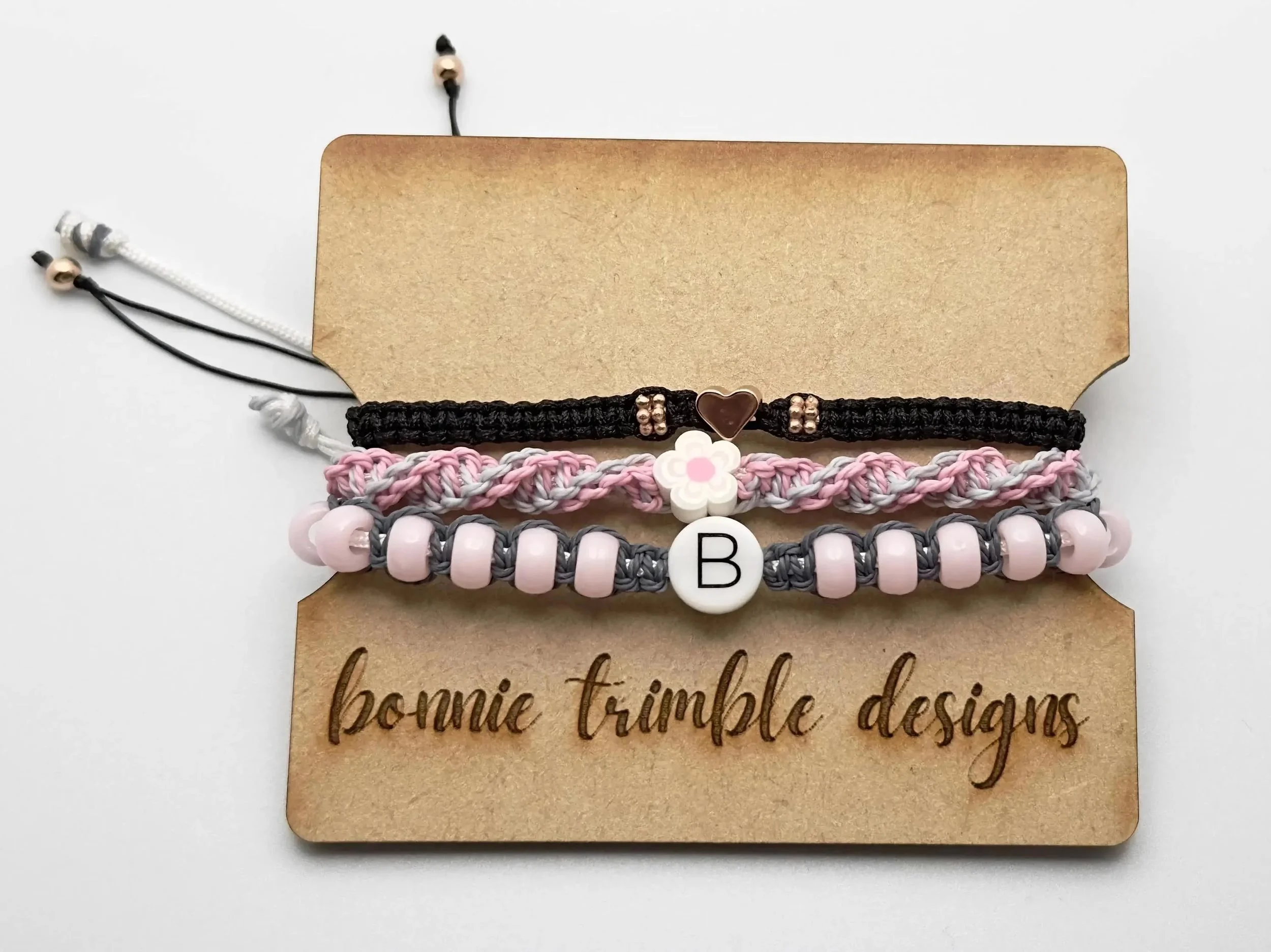 a high-contrast personalized stack showing the artisan texture of macramé paired with luxury metallic charms.