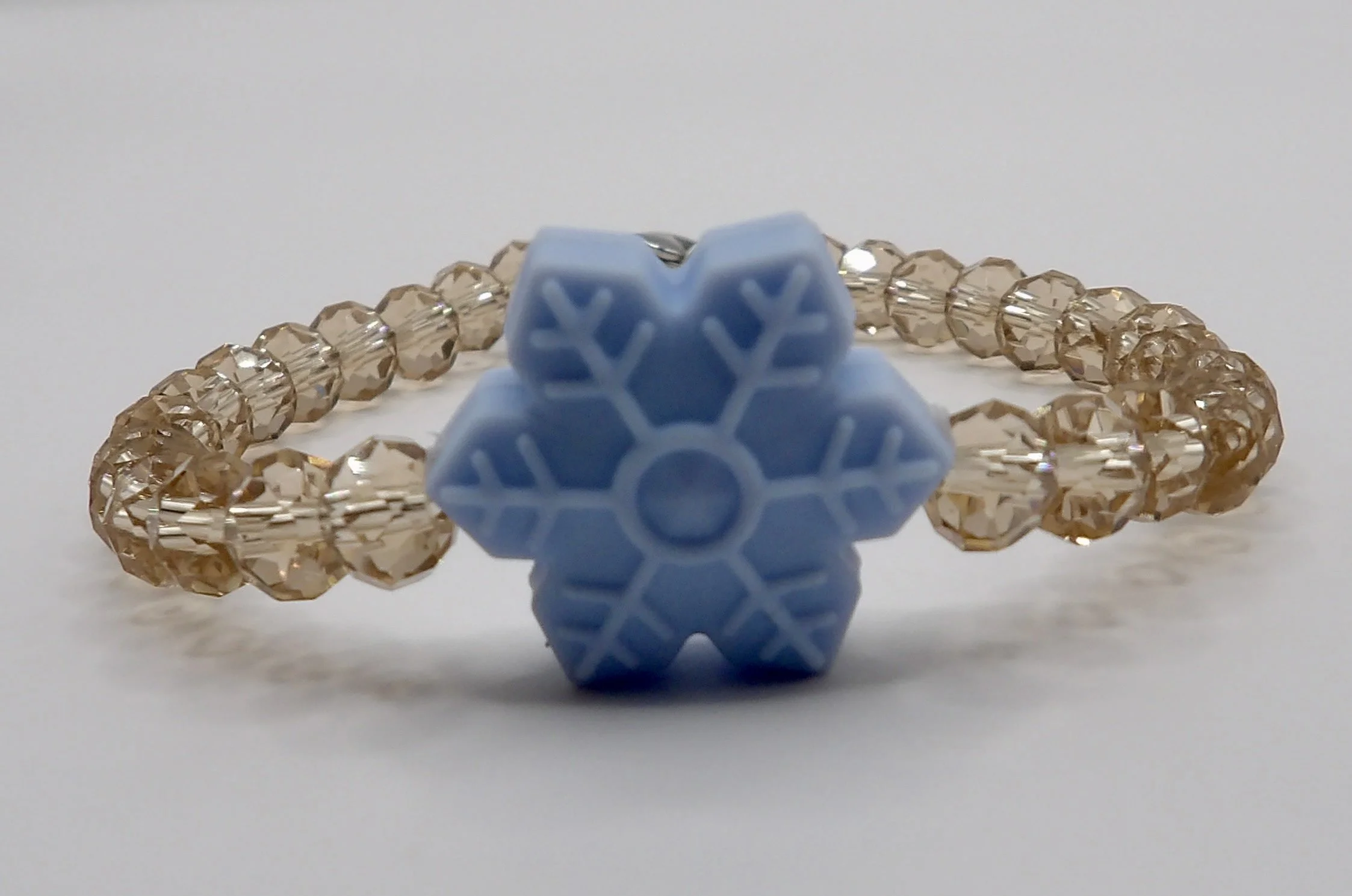 person wearing the dainty deep red glass bead snowflake bracelet, showing its festive holiday style.