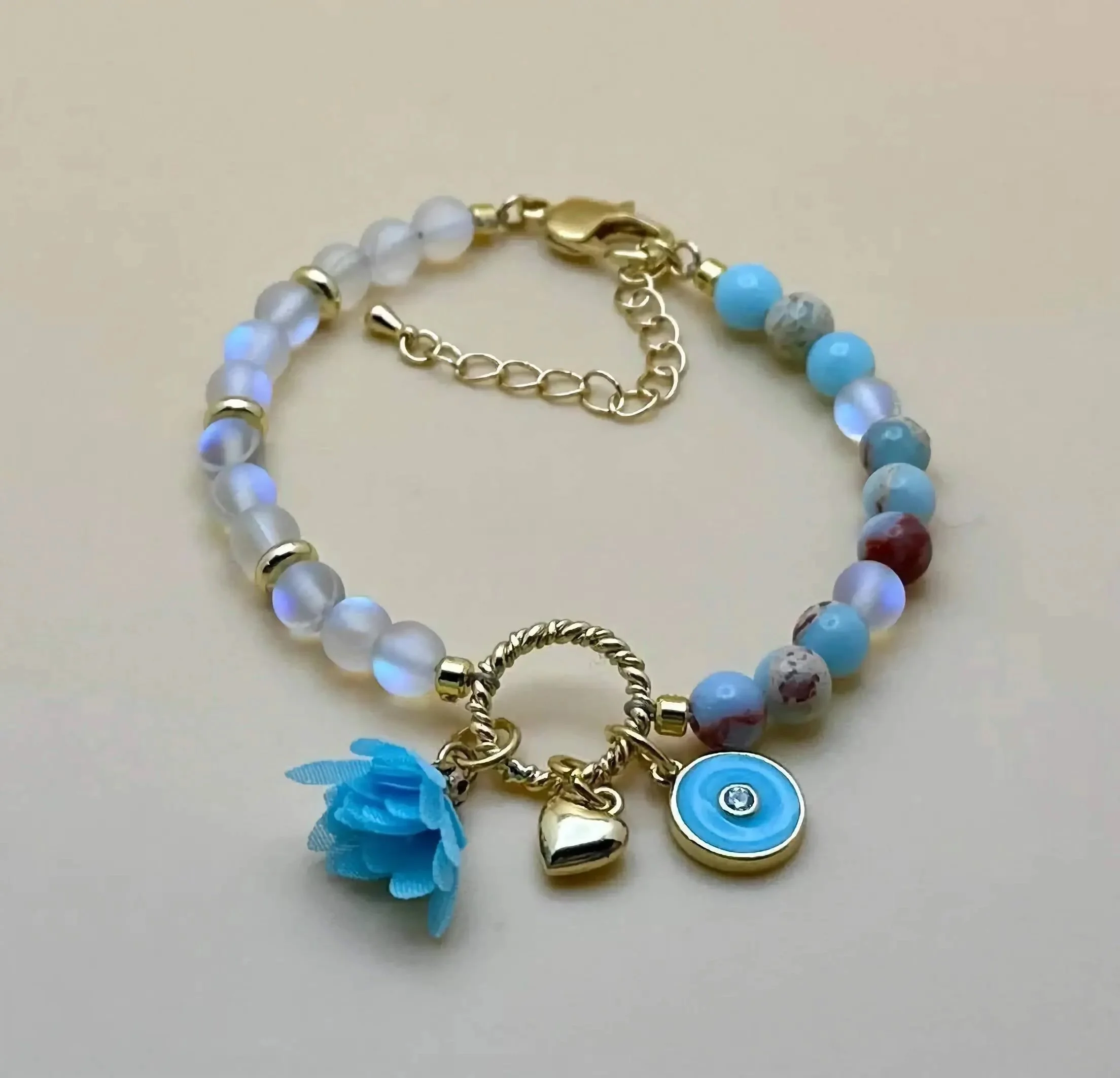 a luxury charm bracelet featuring premium 18k gold filled beads and a centered cluster of natural iridescent stones.