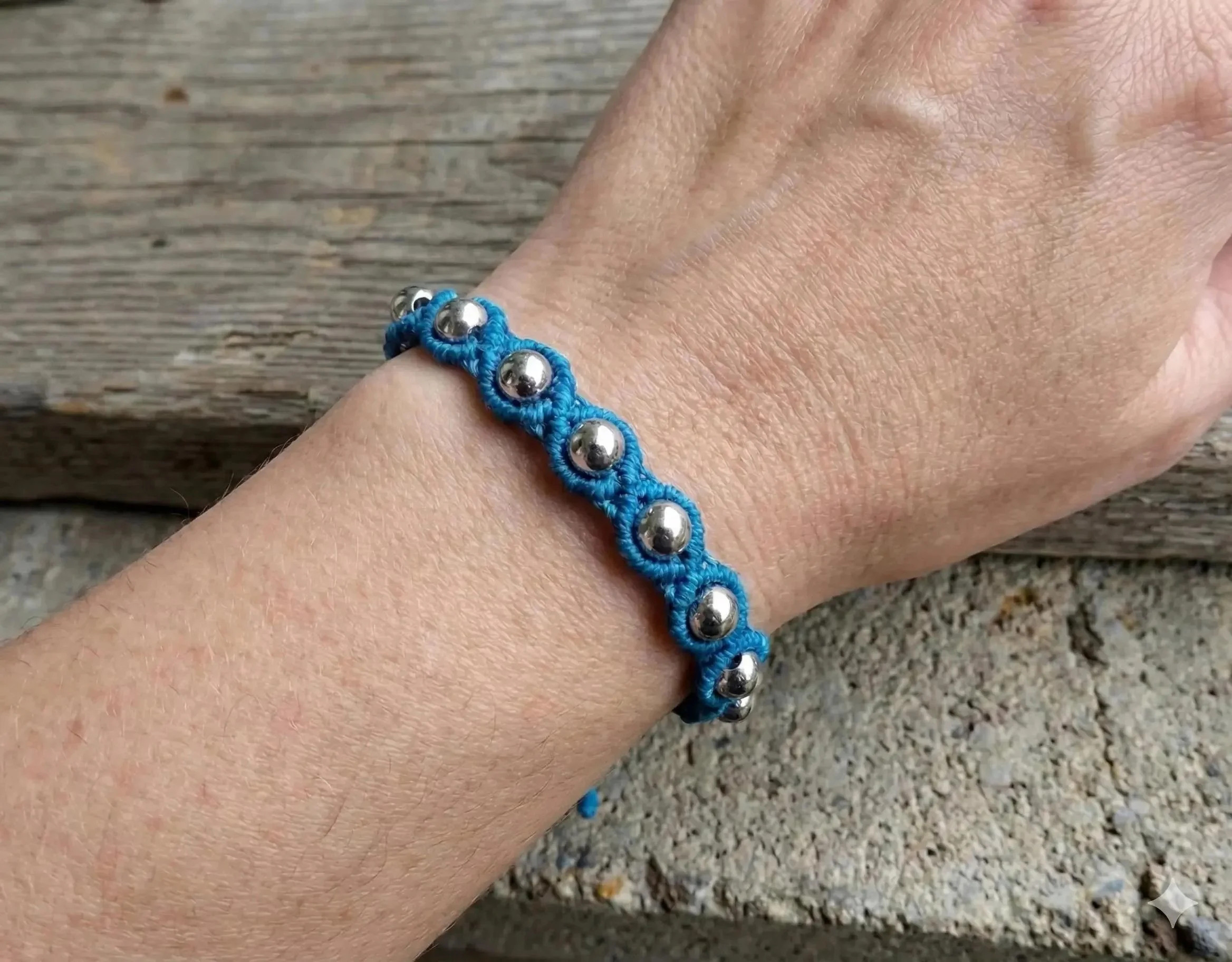 weighted micro-macramé bracelet with polished stainless steel beads woven into a durable, waterproof cord band.