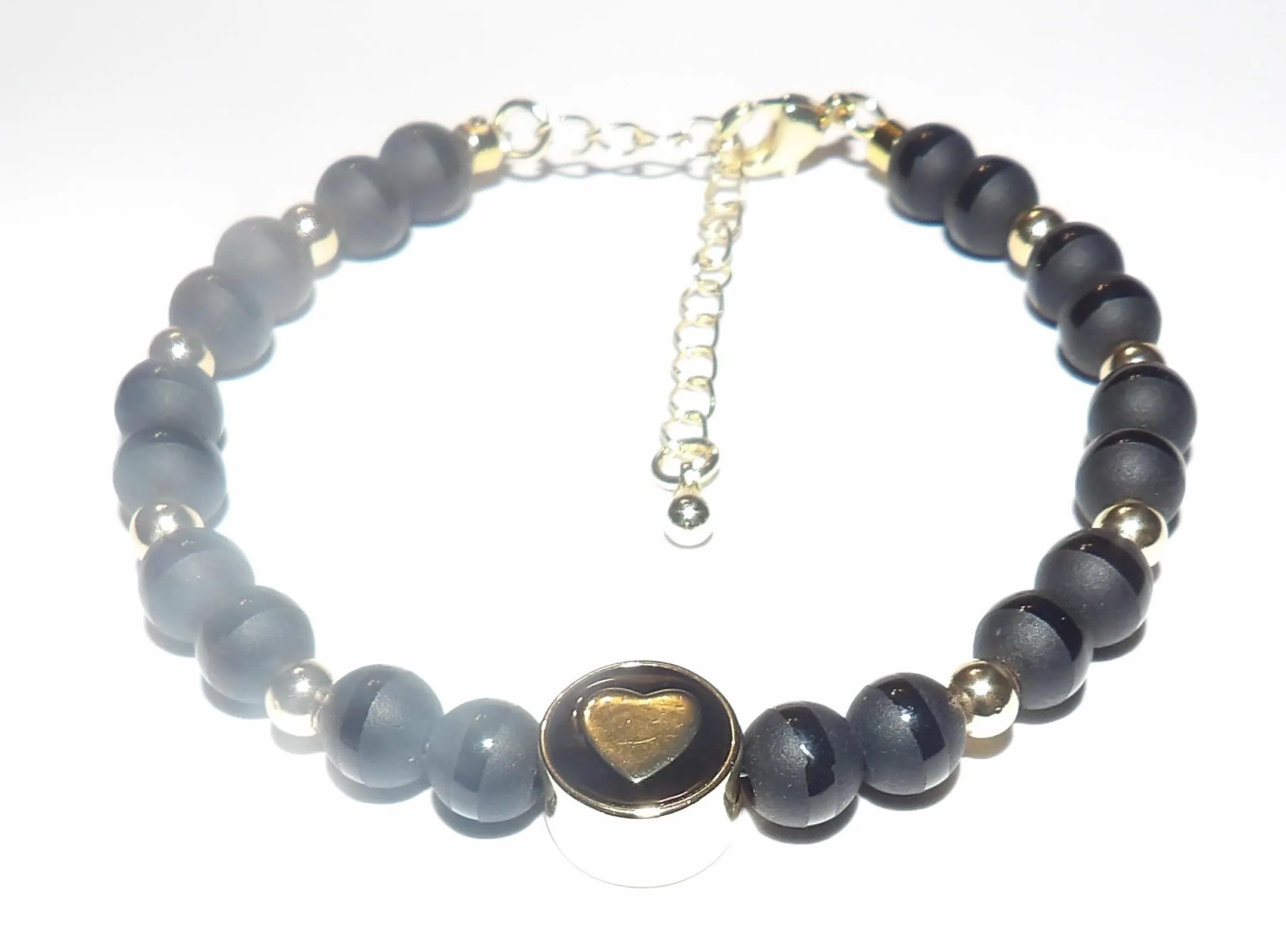 minimalist tuxedo onyx jewelry set featuring a polished gold heart focal and an adjustable closure for a custom fit.