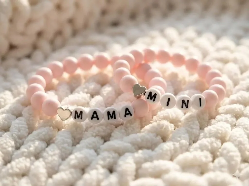 handcrafted mother-daughter jewelry showing two coordinated powder pink bracelets with polished sterling silver hearts.