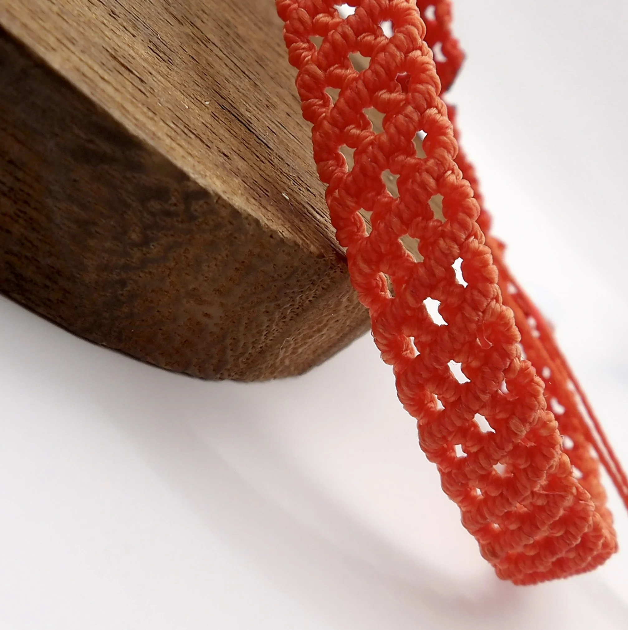 A handmade multi-layer micromacrame bracelet, intricately woven in a versatile dark orange and finished with stainless steel accents.