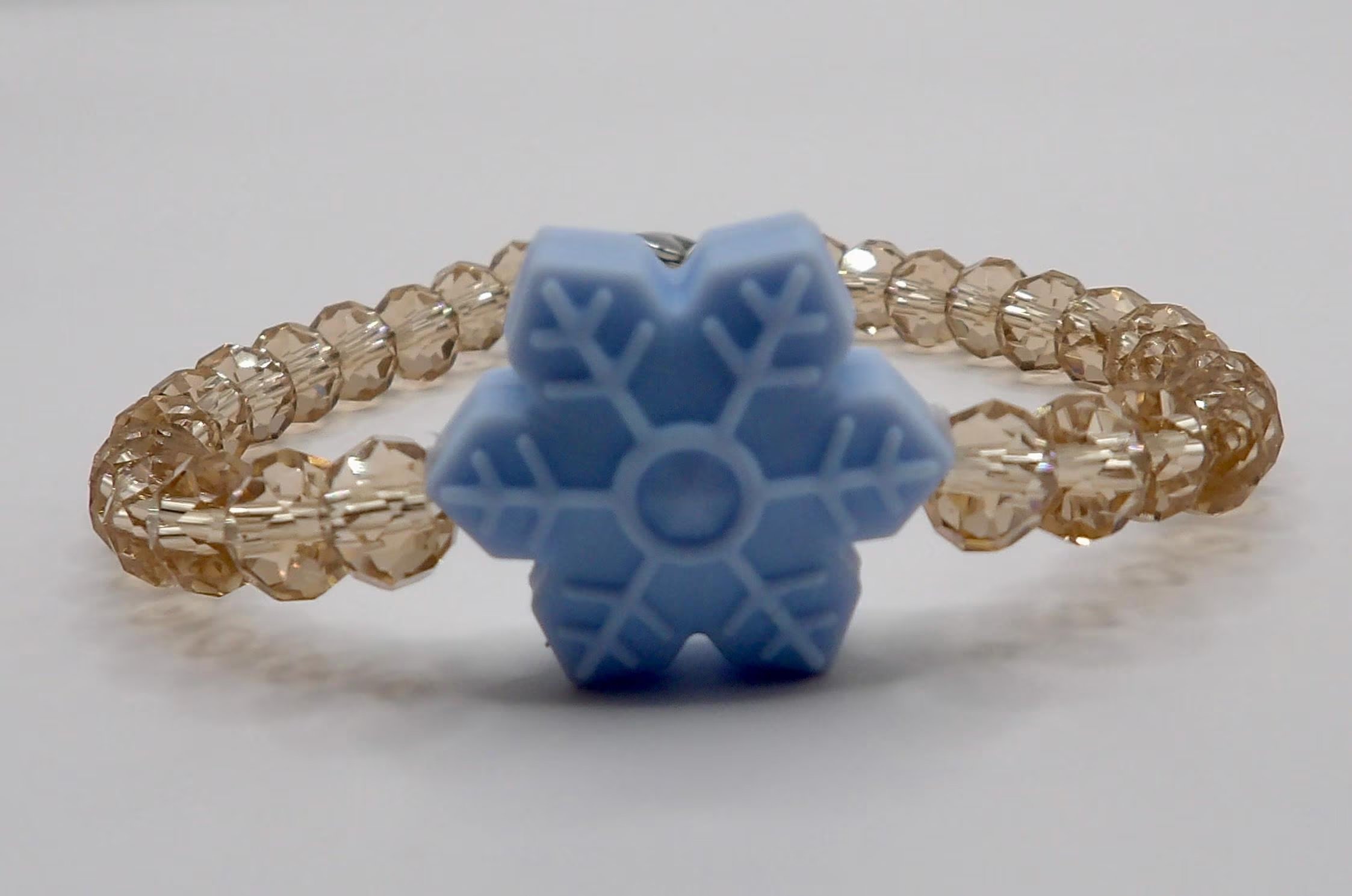 an intentional holiday anchor piece handcrafted with light-refracting beads and a modern snowflake silhouette.
