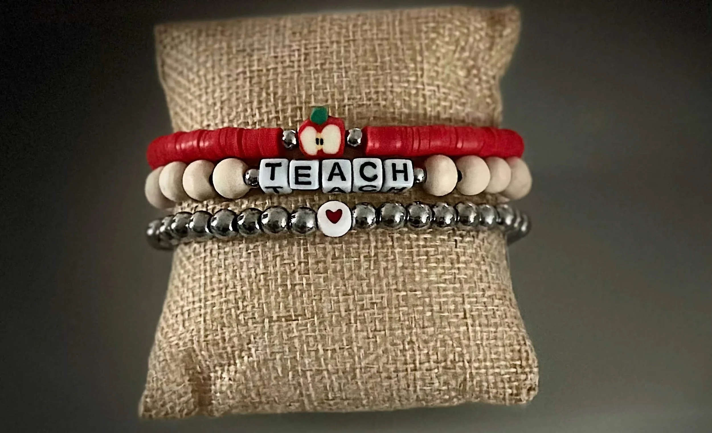 product image of a handmade bracelet for teachers, with a heart, apple, and teach spelled out in beads