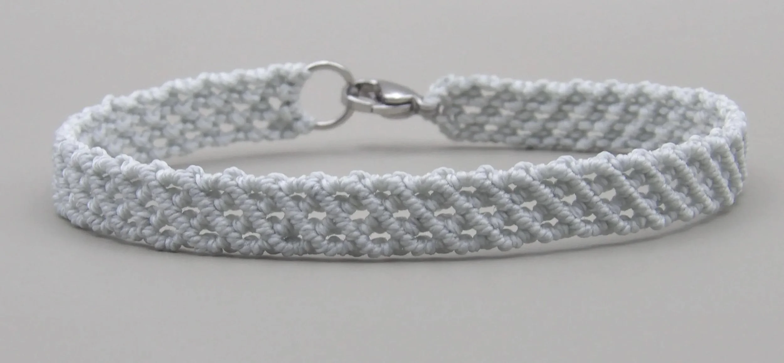 high-resolution product shot of the gray layers bracelet on a dark concrete background to emphasize its industrial roots.