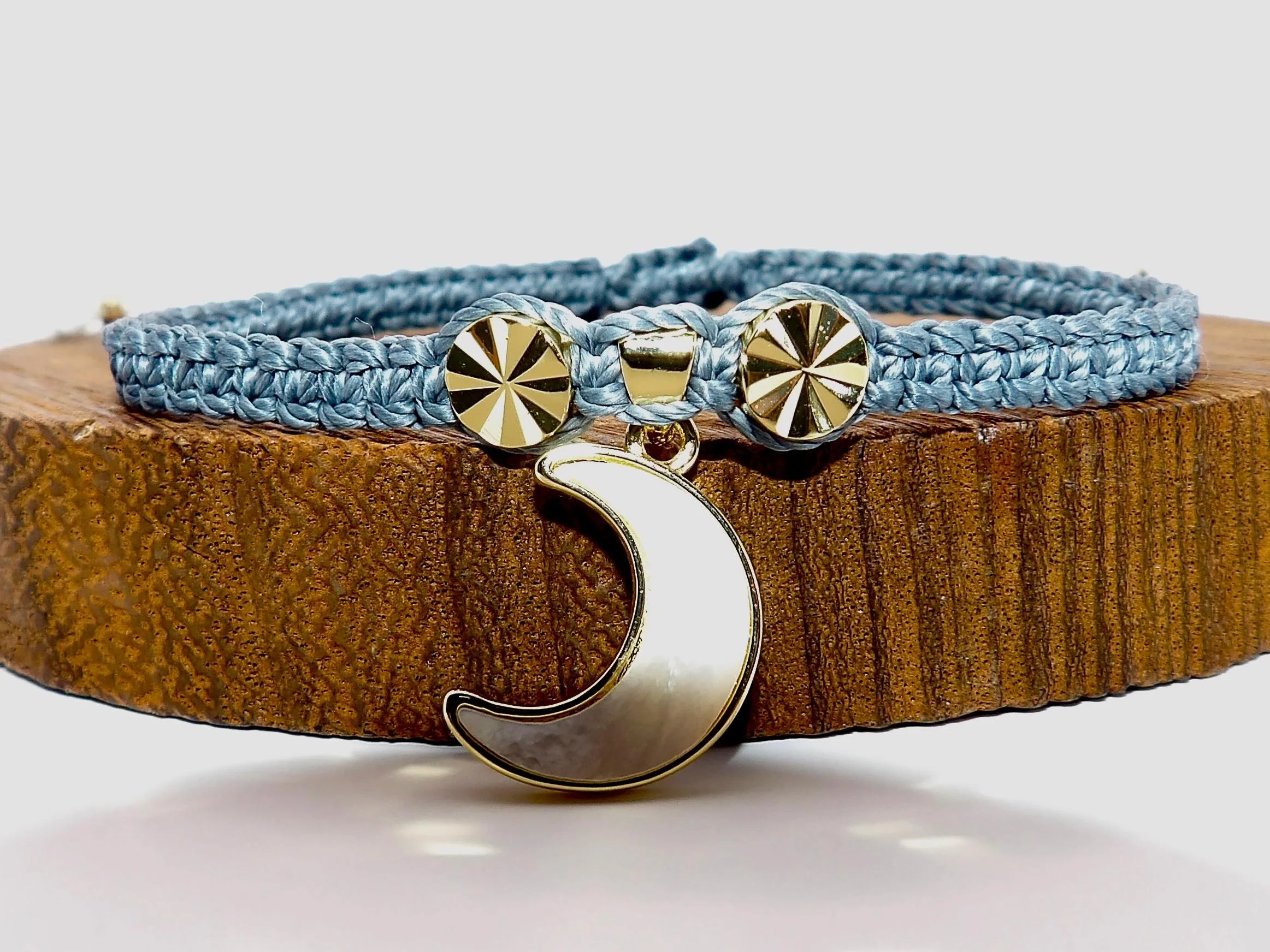 Minimalist celestial moon charm bracelet on a sleek charcoal macramé band for a modern "Executive Armor" look.