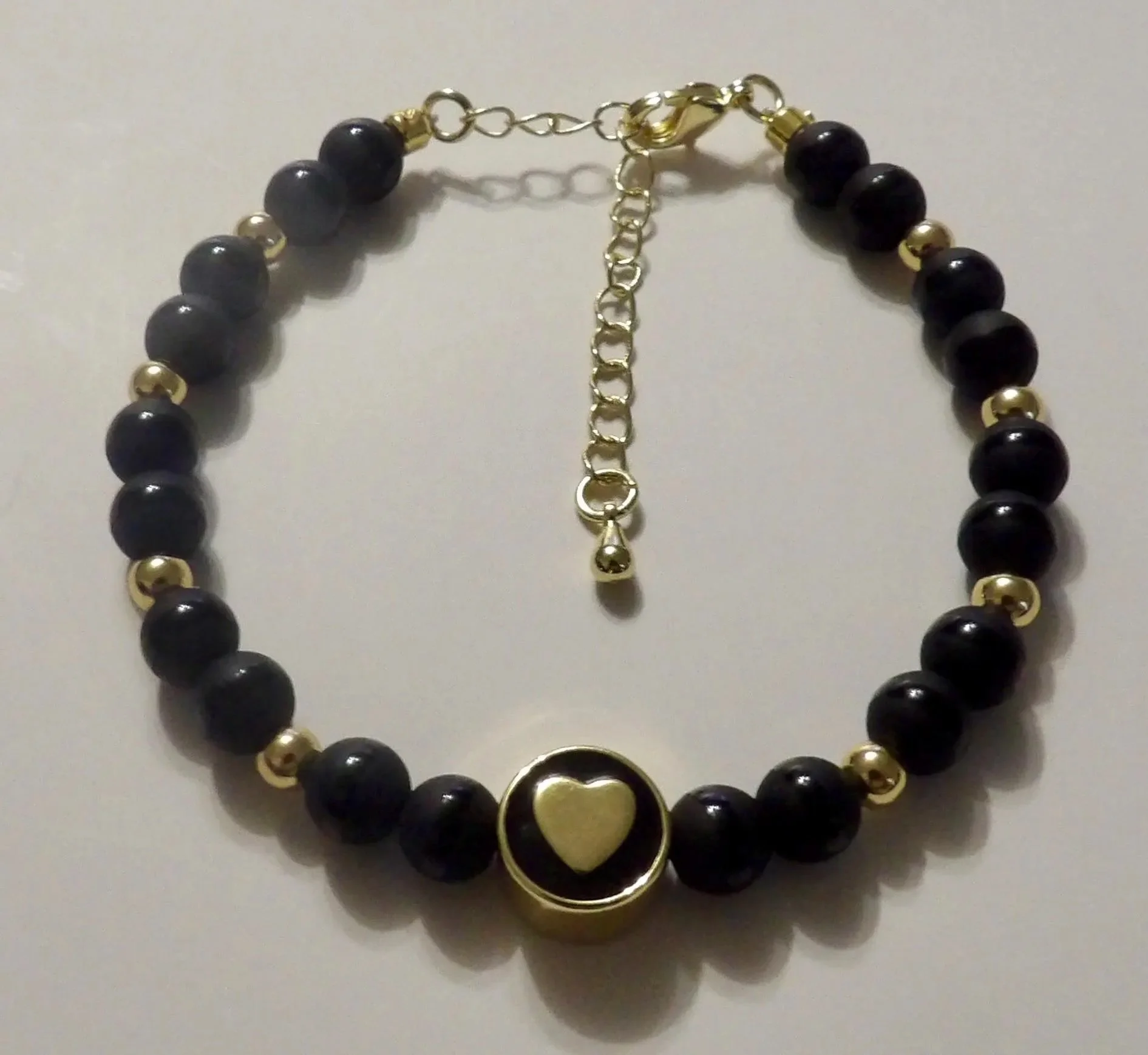 handcrafted 18k gold plated heart and black onyx bracelet showcasing a sophisticated "tuxedo" palette of black and gold.