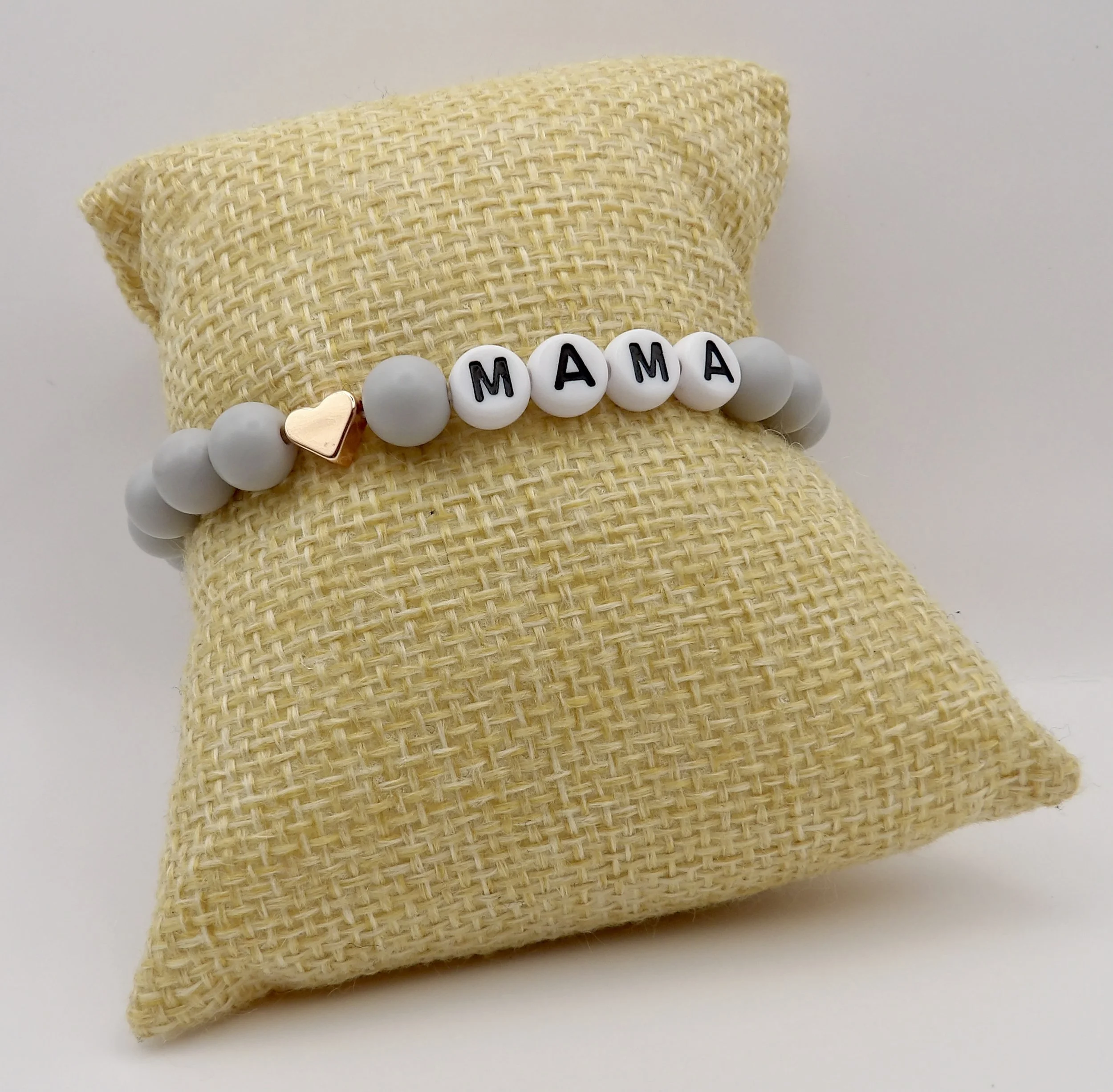 close-up detail of the gray matte beads, “mama” lettering, and the polished rose gold heart accent on the mom bracelet.