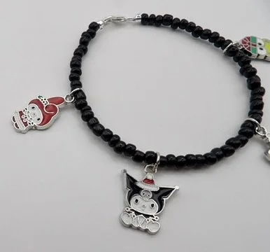 close-up detail of the sterling silver & enamel kuromi charm wearing a santa hat, on the black glass bead bracelet.