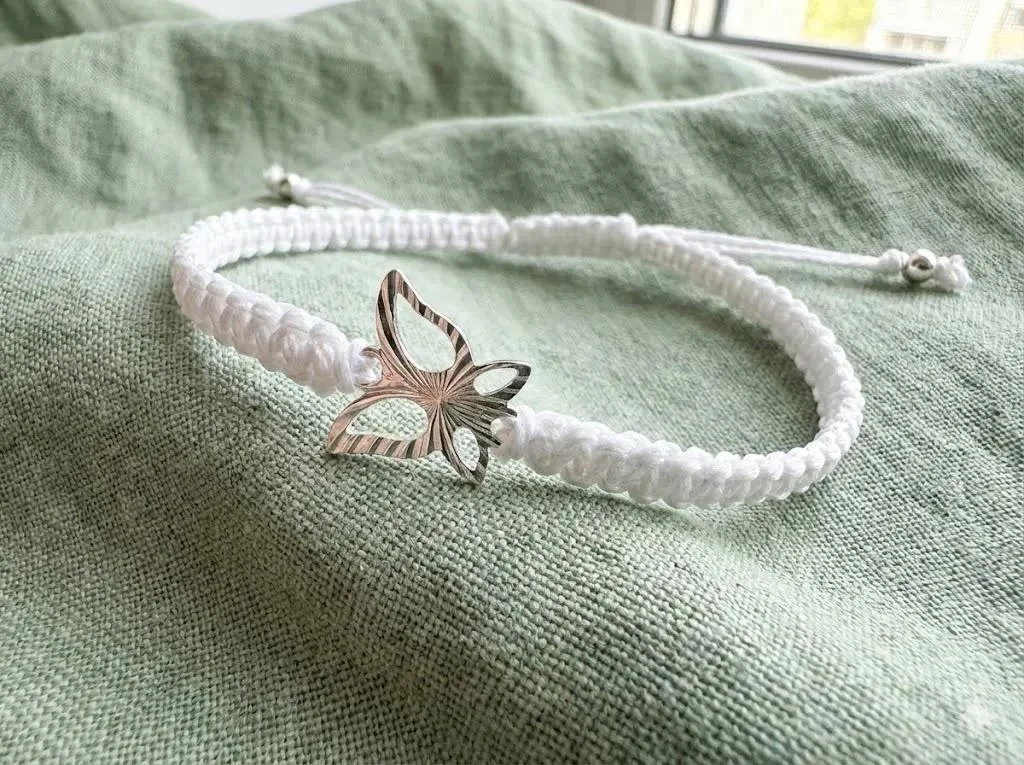 a delicate and romantic white jewelry piece showing the shimmering silver butterfly focal and adjustable sliding knot.