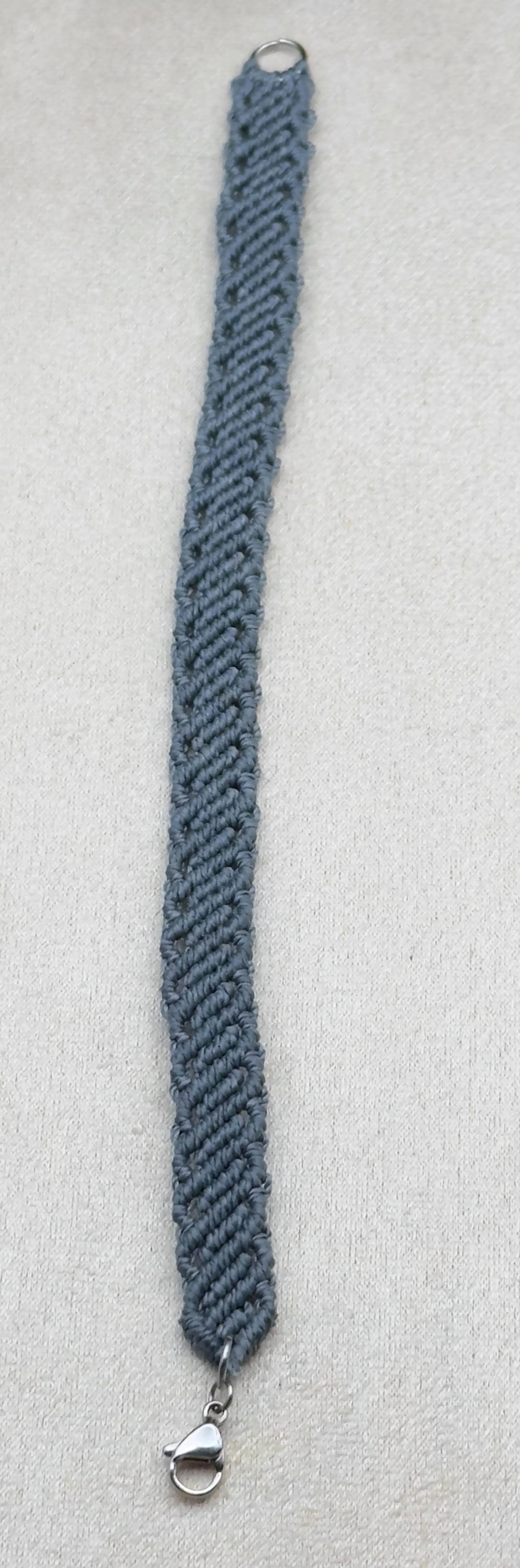 A unique micro macrame bracelet for men, styled with a leather watch and a rugged notebook.
