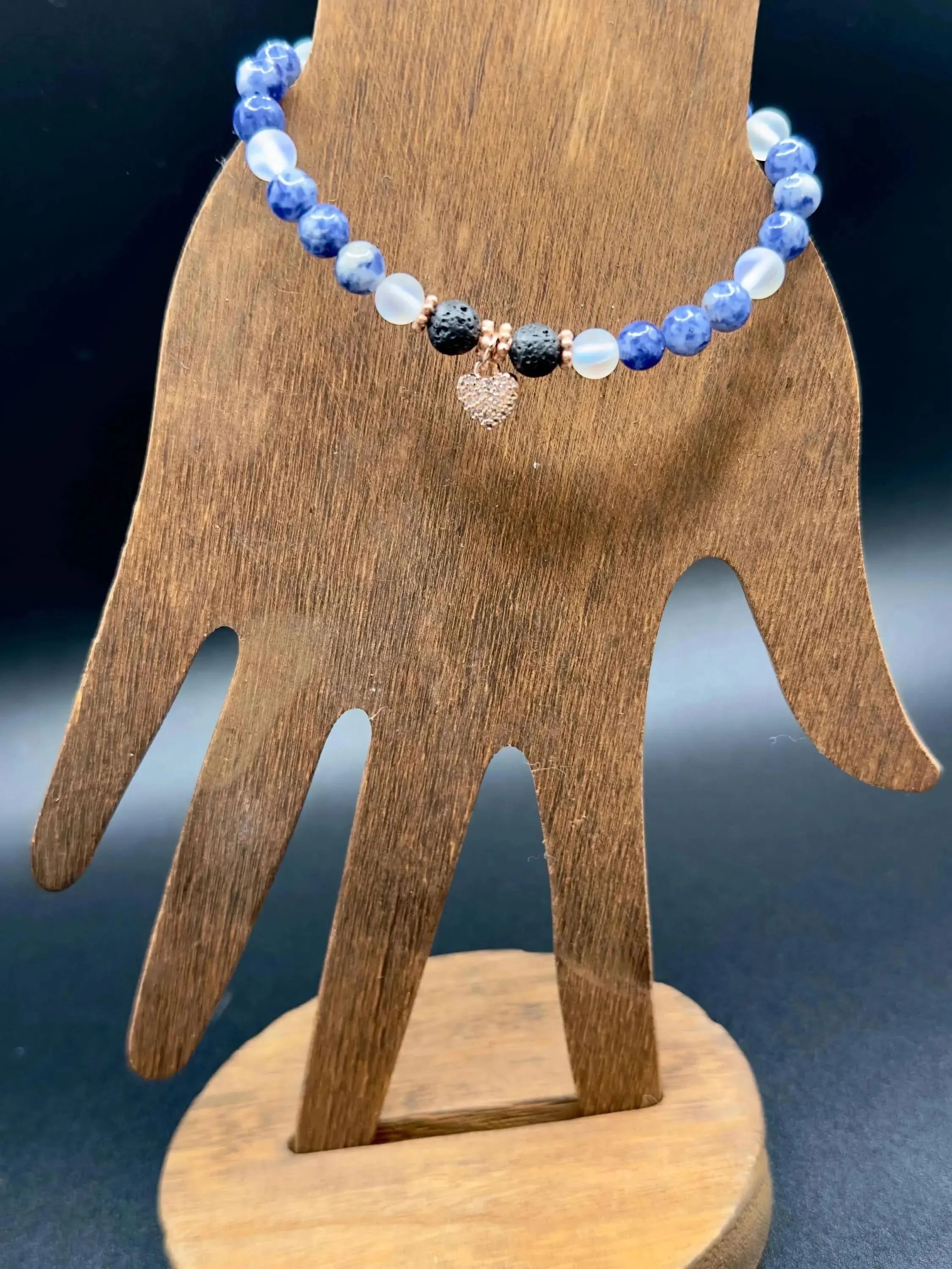 the whimsical blue cluster bracelet styled on a coastal-inspired background to emphasize its "oceanic ether" aesthetic.
