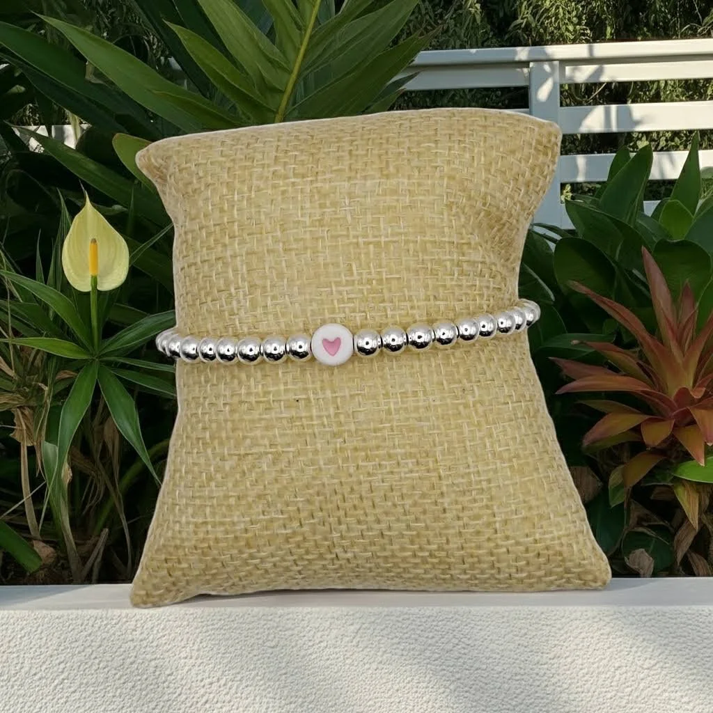 dainty 5mm sterling silver beaded bracelet featuring a round white acrylic charm with a pink heart.