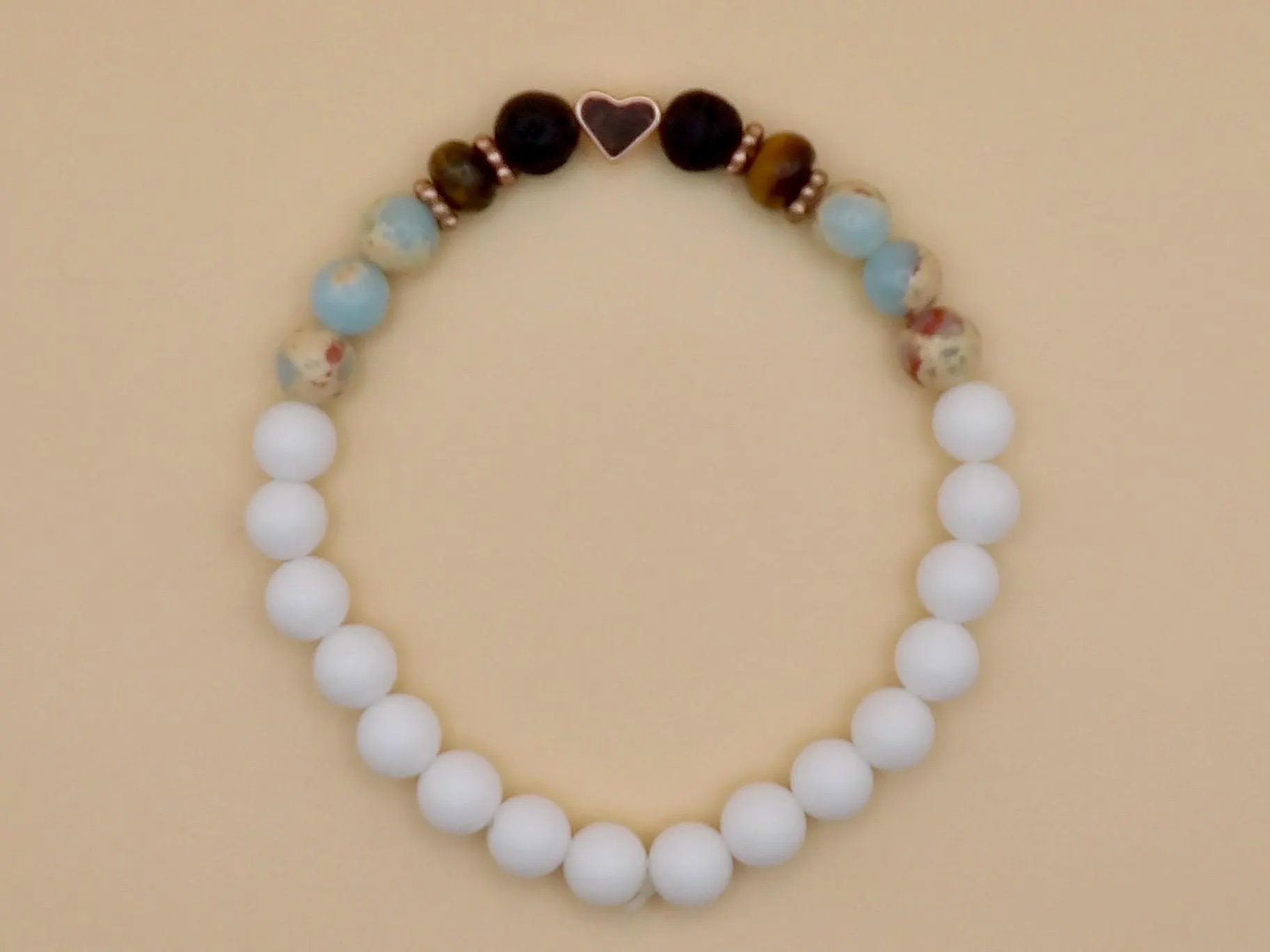 a tactile and grounding stacking bracelet featuring mixed gemstones for emotional balance and a signature rose gold heart focal.