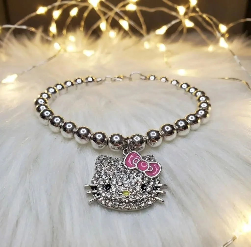 a luxury nostalgia-core bracelet showing the reflective sterling silver beads paired with a shimmering pink mosaic kitty focal.