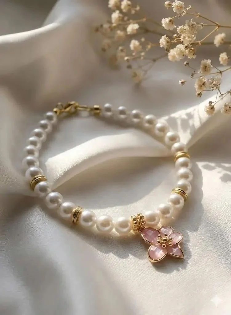 a dainty and hypoallergenic pearl bracelet showing the natural shimmer of mother of pearl and a high-shine gold flower.