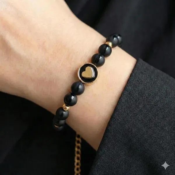 the classic minimalist bracelet featuring a 18k gold plated heart charm centered between matte and polished tuxedo onyx beads.