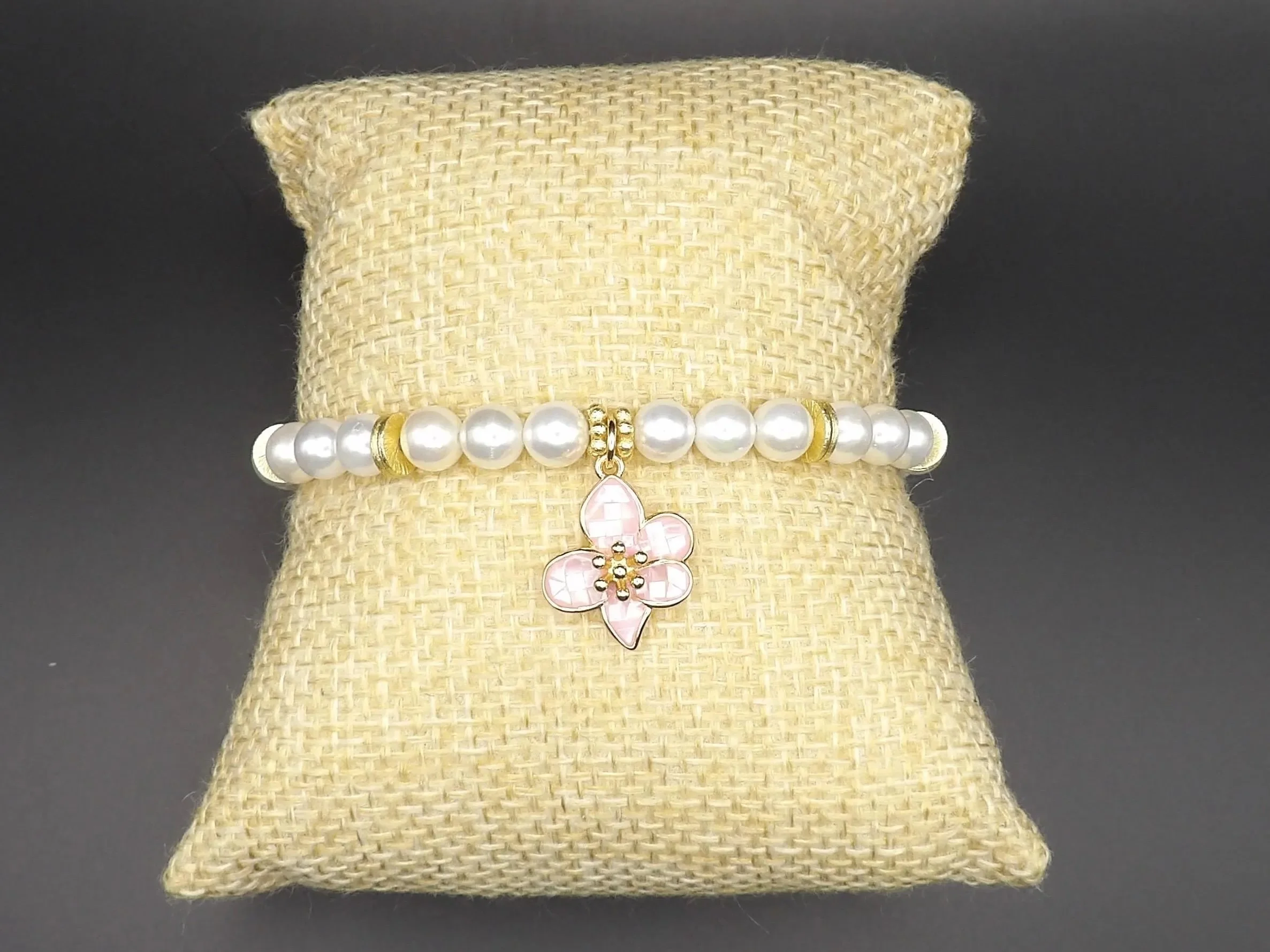 detailed view of the 18k triple gold plating on the classic bloom flower and the creamy luster of the mother of pearl beads.