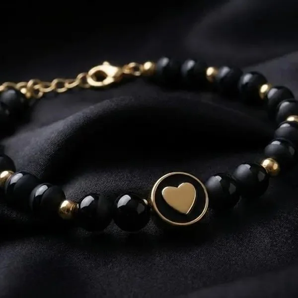 minimalist black onyx tuxedo bracelet featuring a dainty gold heart charm.