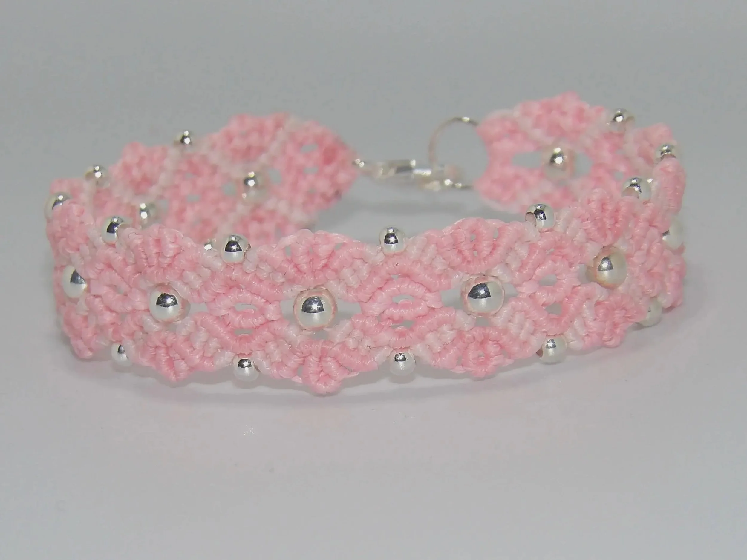 a sophisticated and romantic artisan bracelet featuring a 3D-effect woven flower and adjustable sliding knot.