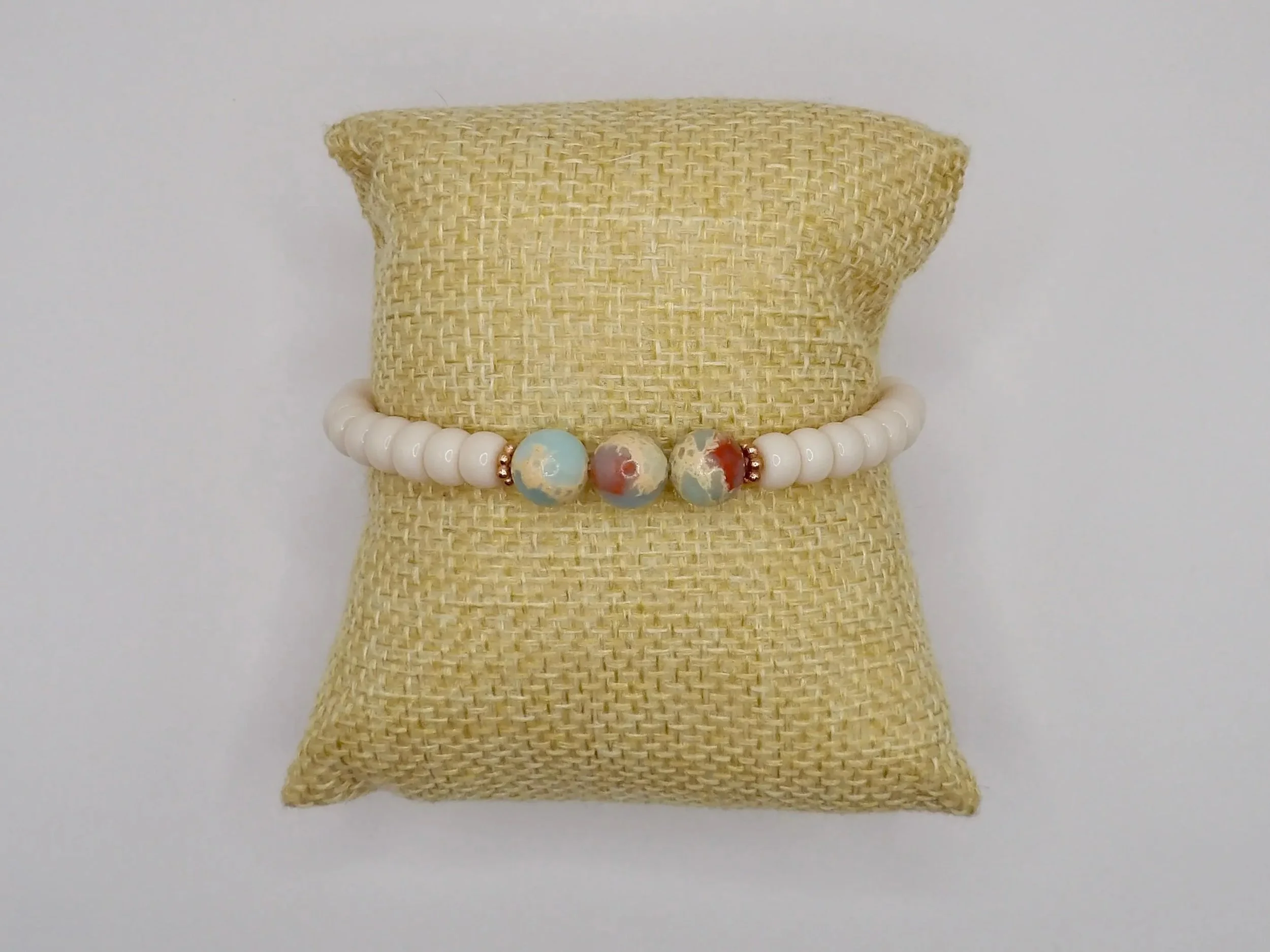 an airy, beach-inspired anchor bracelet designed with a signature blue and cream color palette and rose gold plated details.