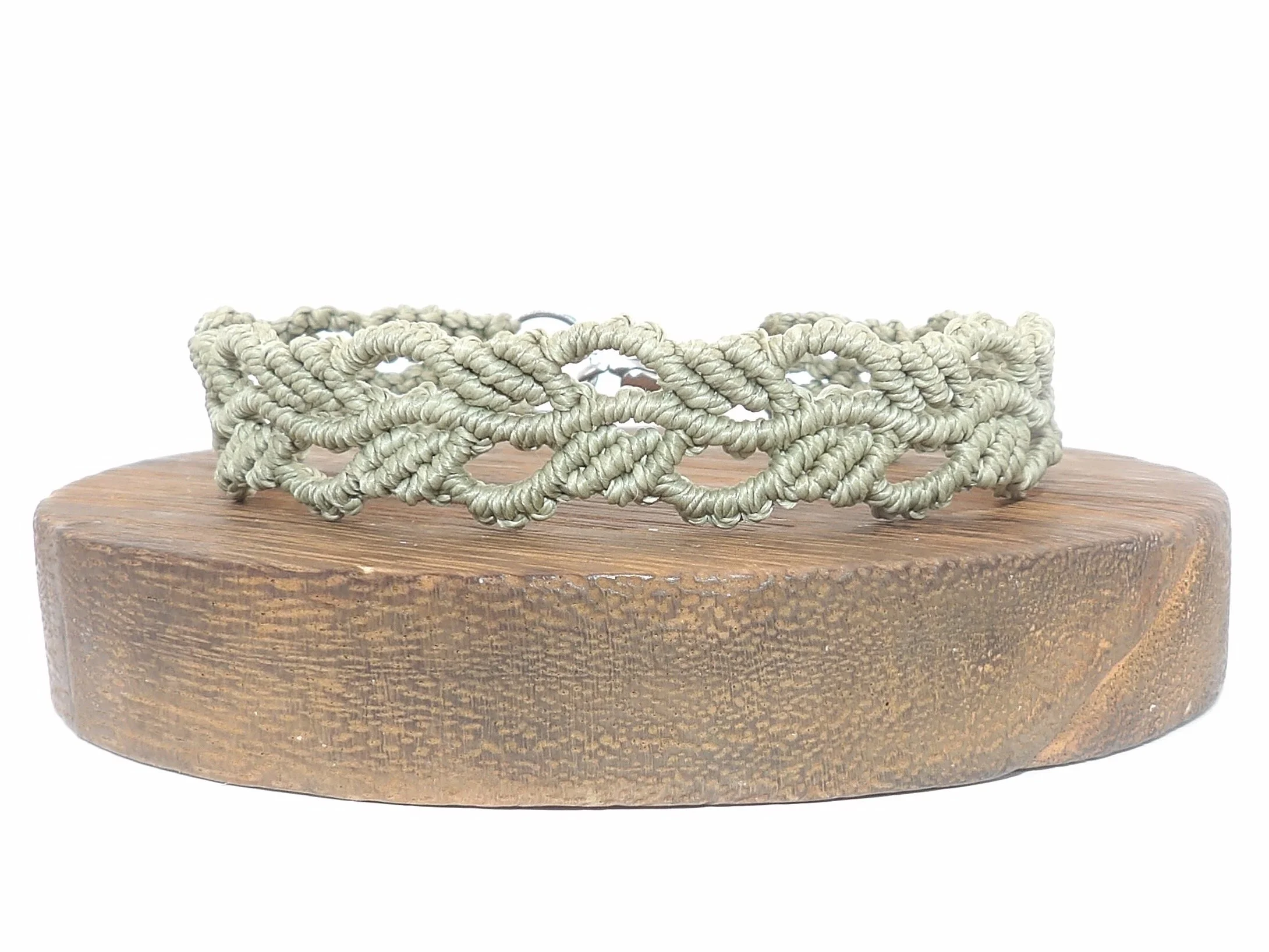 A handmade micromacrame bracelet with intricately woven green ivy leaves, shown flat on a white background with its stainless steel lobster clasp visible.