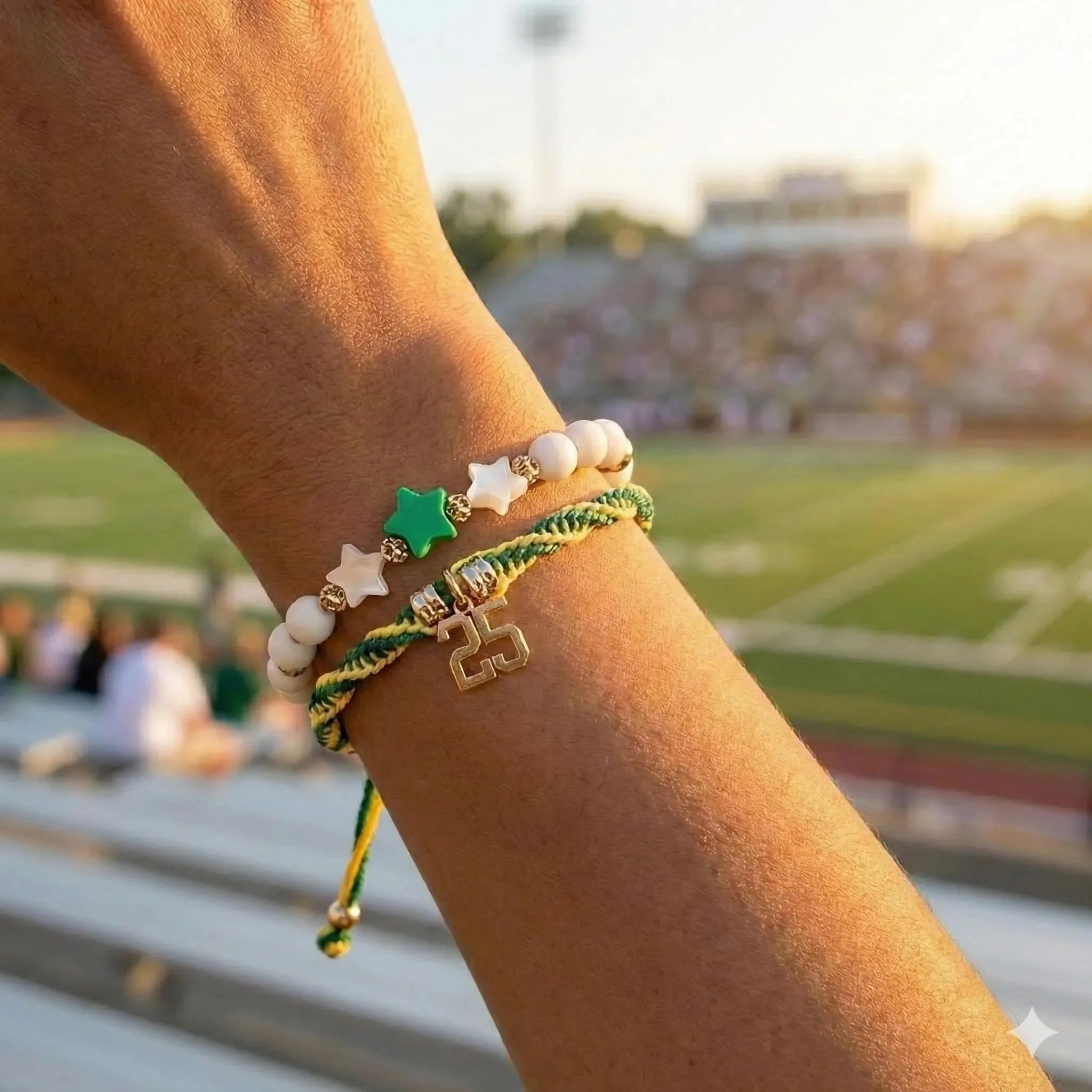 graduation bracelet stack on a wrist featuring an 18k gold pvd number charm, white jade beads, and a custom star.