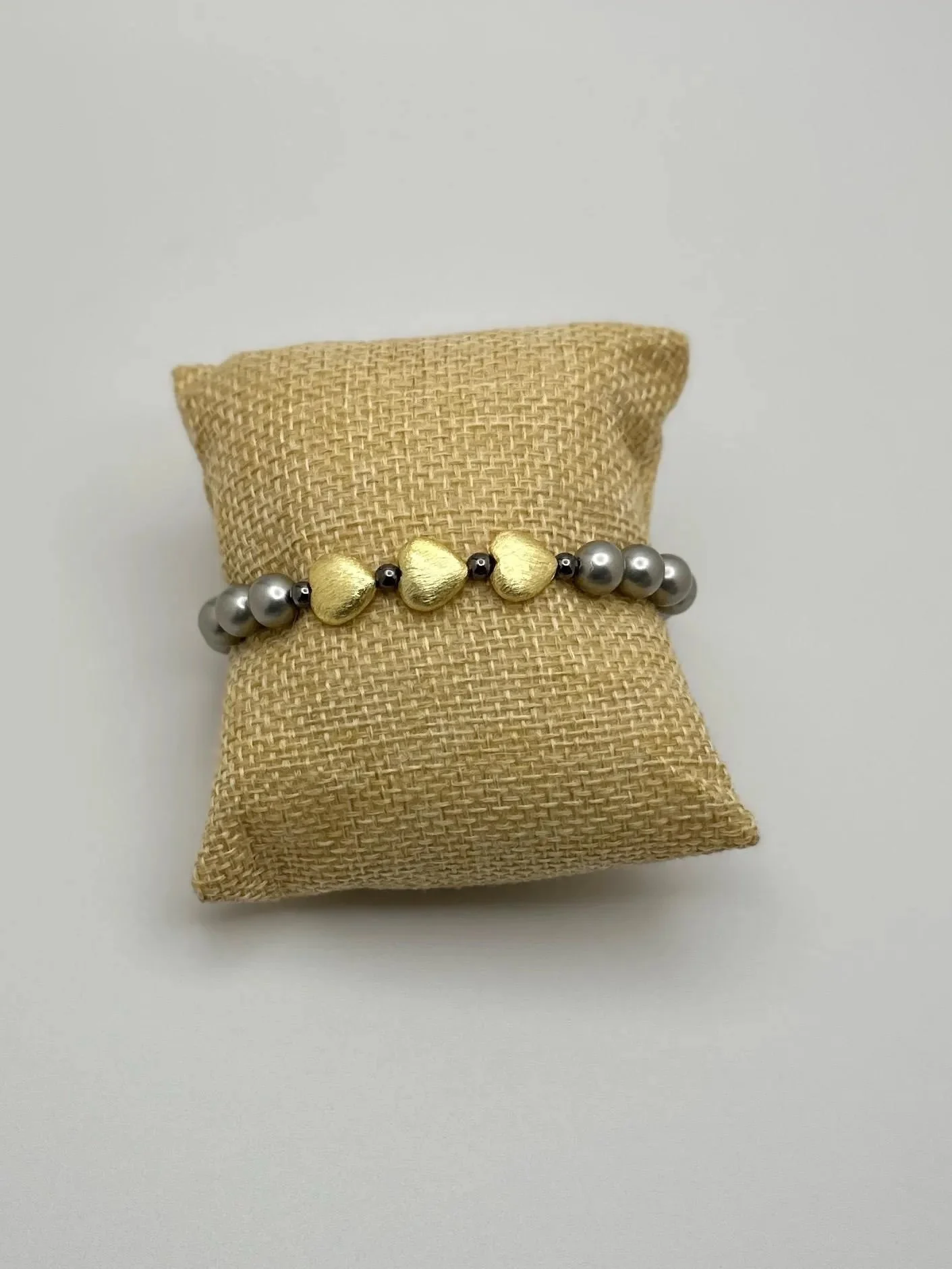 an edgy yet elegant stacking bracelet featuring dark iridescent pearls and metallic gunmetal-tone accents.