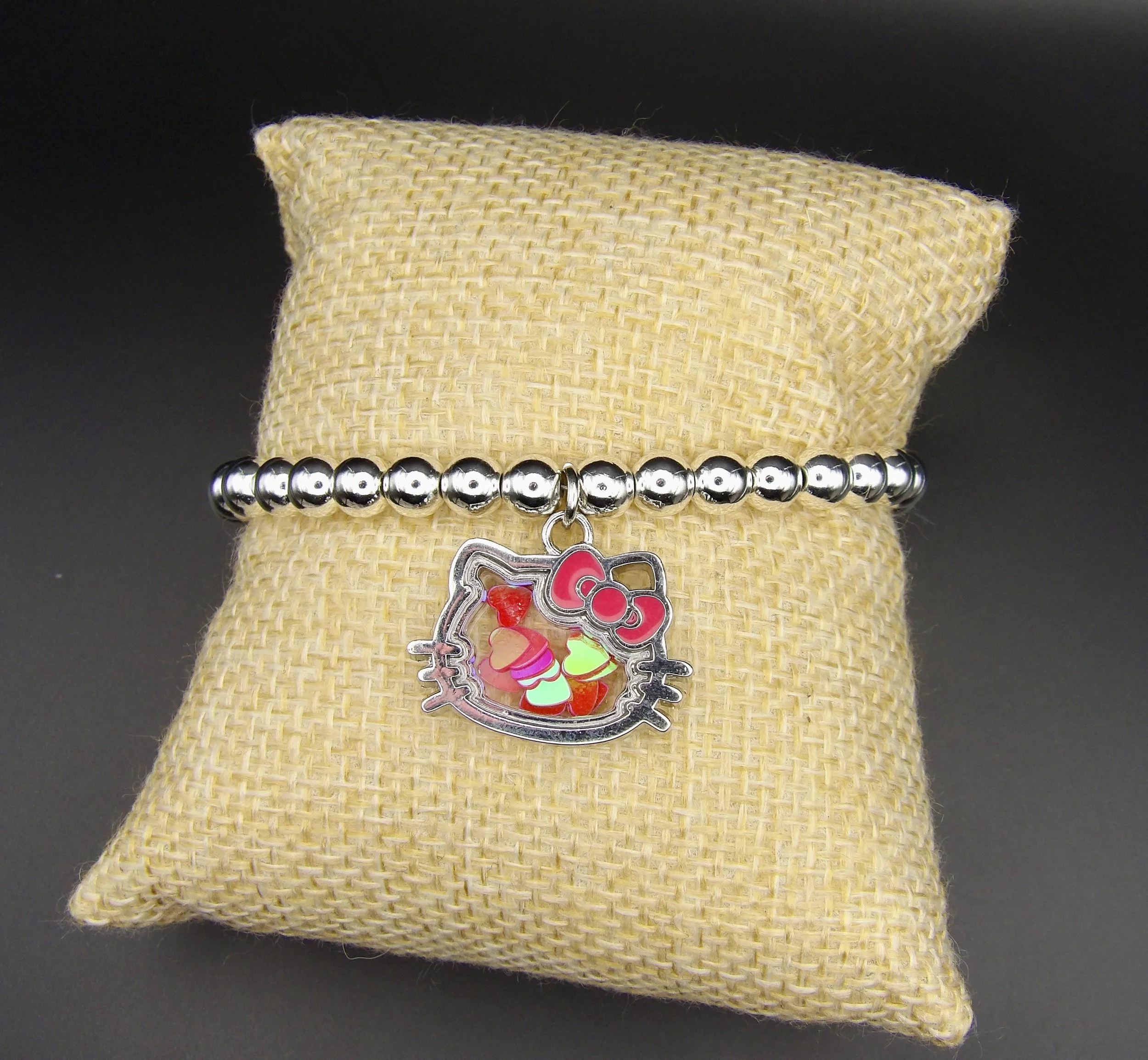 detailed view of the .925 sterling silver hallmark and the intricate liquid-like movement of the hello kitty shaker charm.