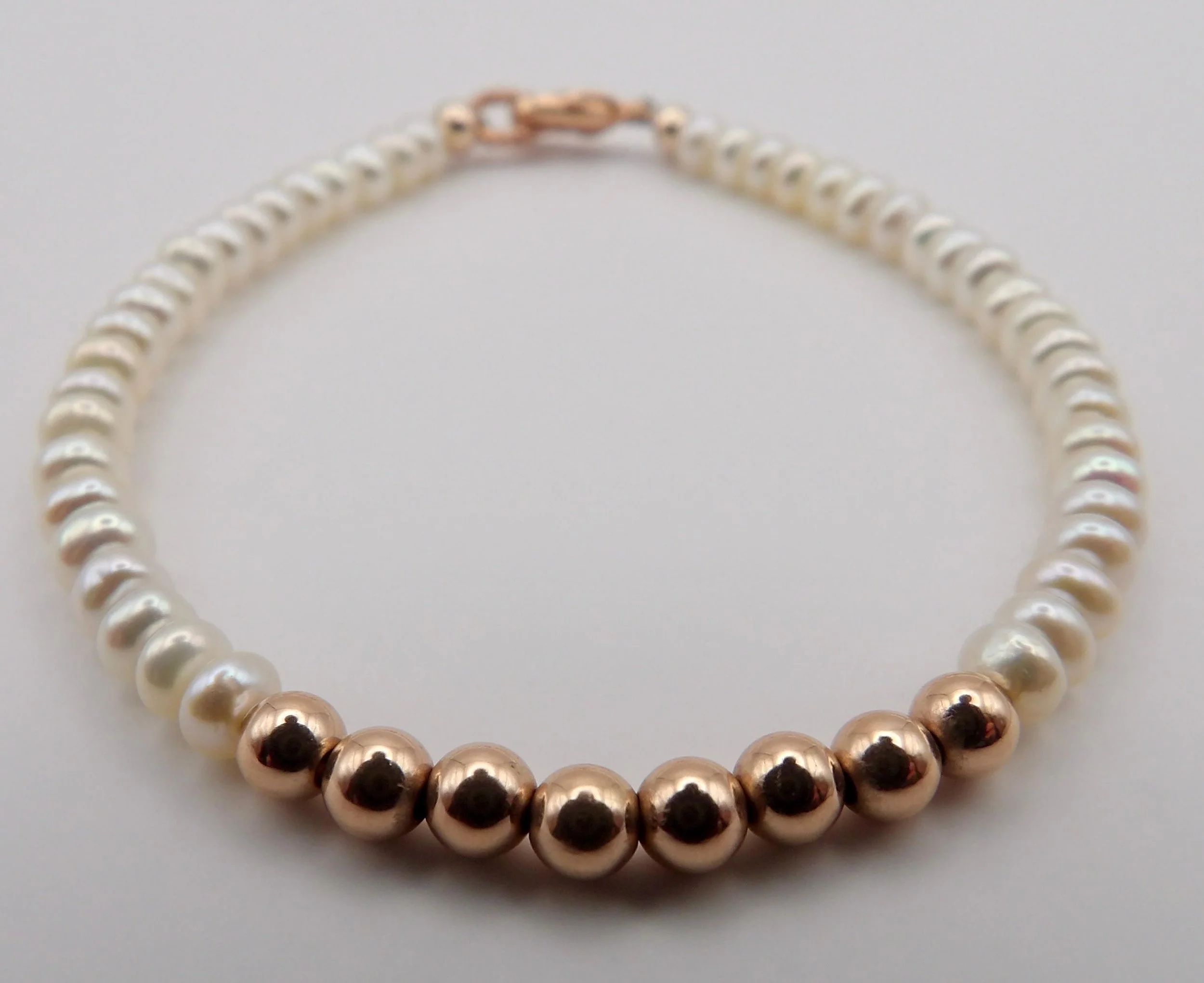close-up of the classic romantic pearl bracelet highlighting the high-quality finish of the rose gold filled hardware.