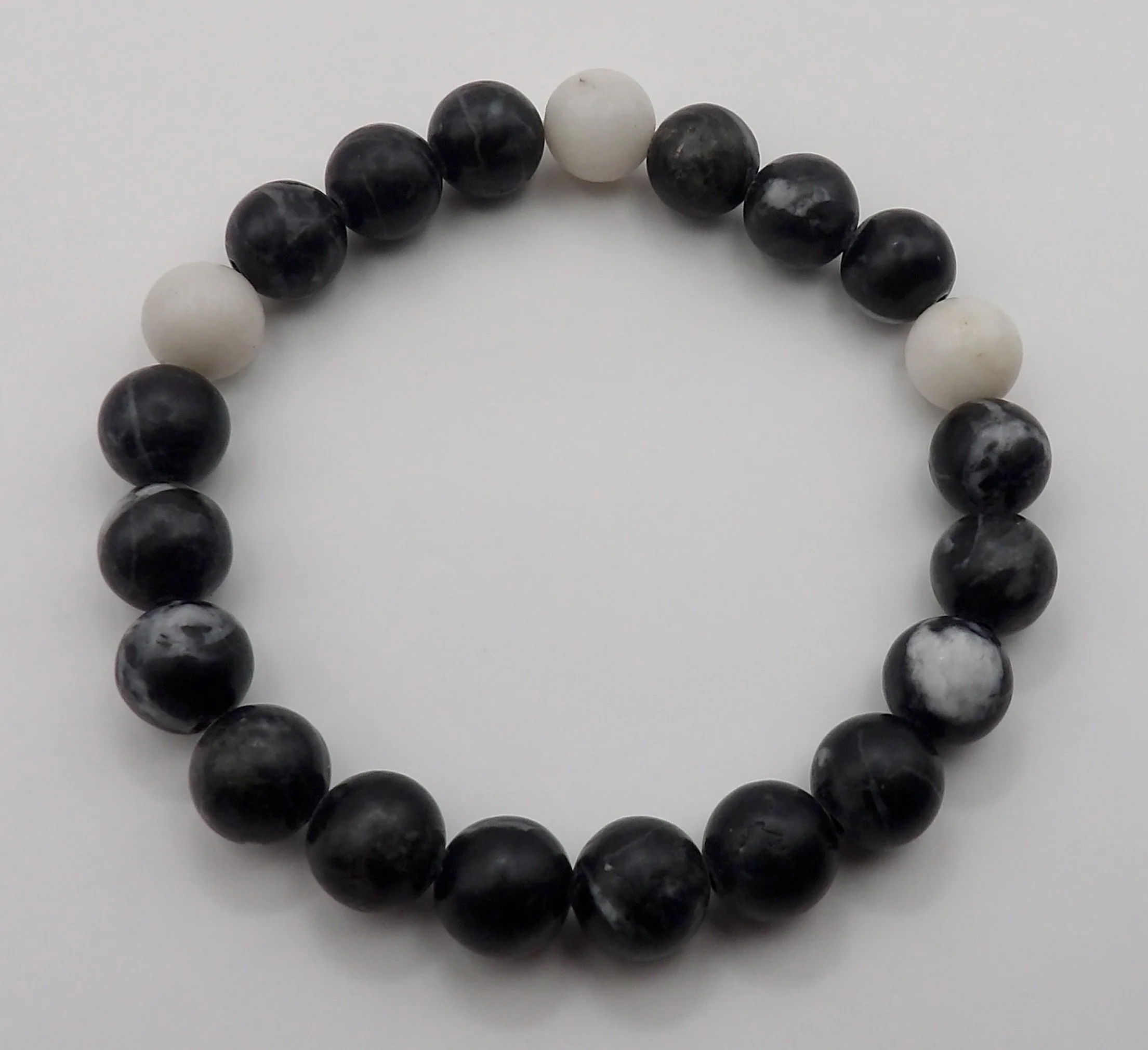 handmade 8mm zebra jasper gemstone bracelet featuring unique black and white striped patterns. unisex stretch fit.